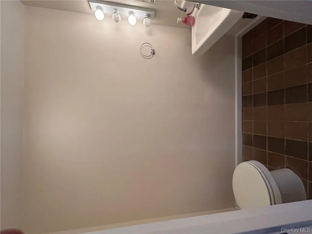 Bathroom with toilet, sink, and tile in showroom Bathroom with toilet, sink, and tile in showroom