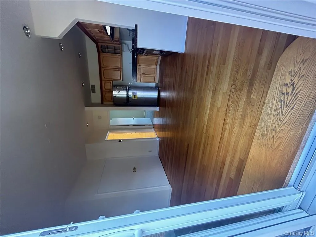 Kitchen with dark hardwood / wood-style flooring, range hood, and refrigerator Kitchen with dark hardwood / wood-style flooring, range hood, and refrigerator