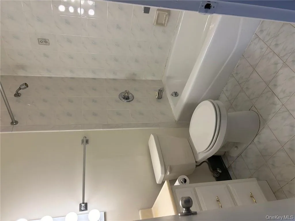 Full bathroom featuring tiled shower / bath, vanity, and toilet Full bathroom featuring tiled shower / bath, vanity, and toilet