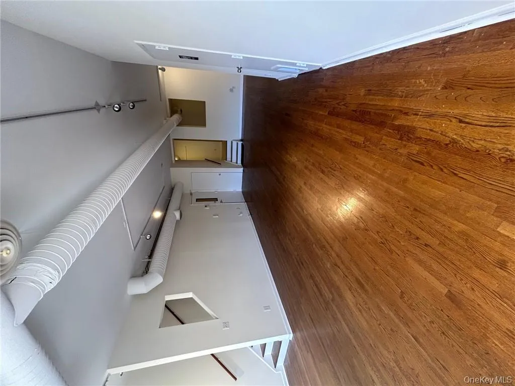 Unfurnished living room with track lighting and dark wood-type flooring Unfurnished living room with track lighting and dark wood-type flooring