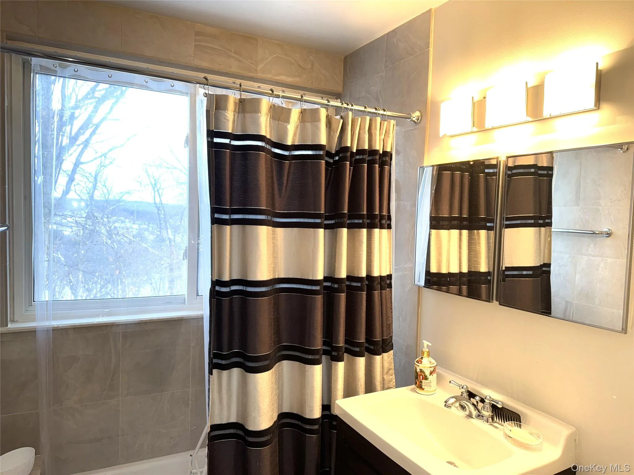 Full bathroom featuring vanity and shower / bath combo with shower curtain Full bathroom featuring vanity and shower / bath combo with shower curtain
