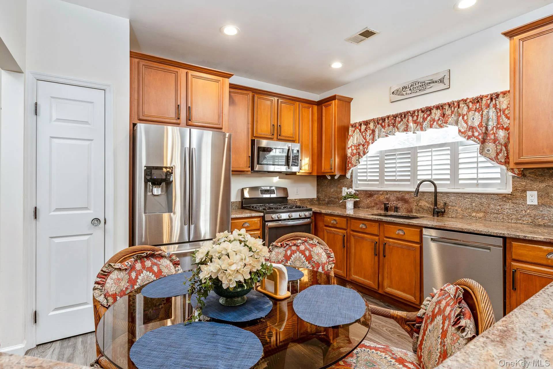 Kitchen featuring light stone countertops, brown cabinets, and recessed lighting Kitchen featuring light stone countertops, brown cabinets, and recessed lighting