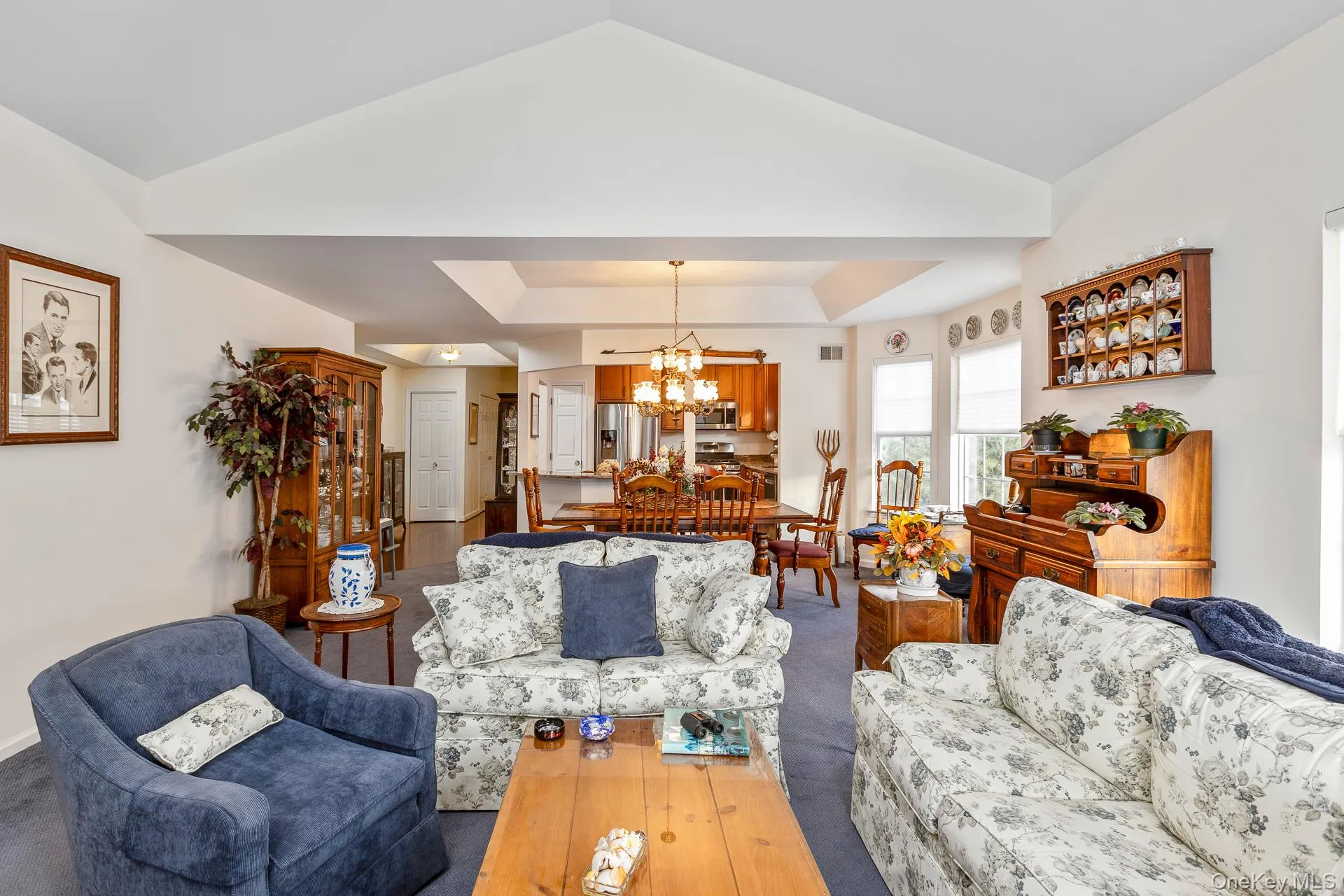 Living room featuring a chandelier and lofted ceiling Living room featuring a chandelier and lofted ceiling