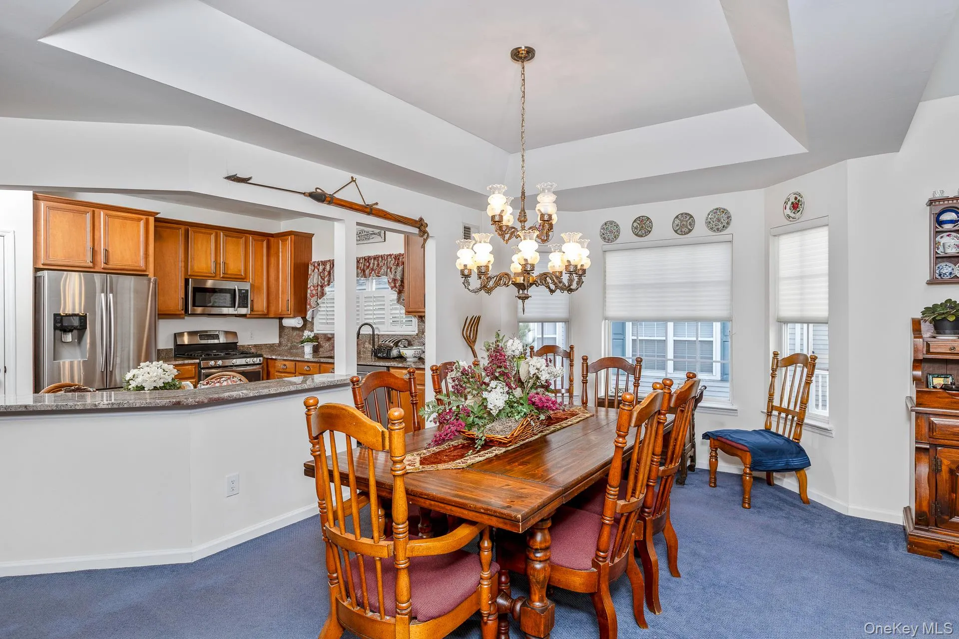 Dining room featuring a chandelier, dark colored carpet, and a tray ceiling Dining room featuring a chandelier, dark colored carpet, and a tray ceiling