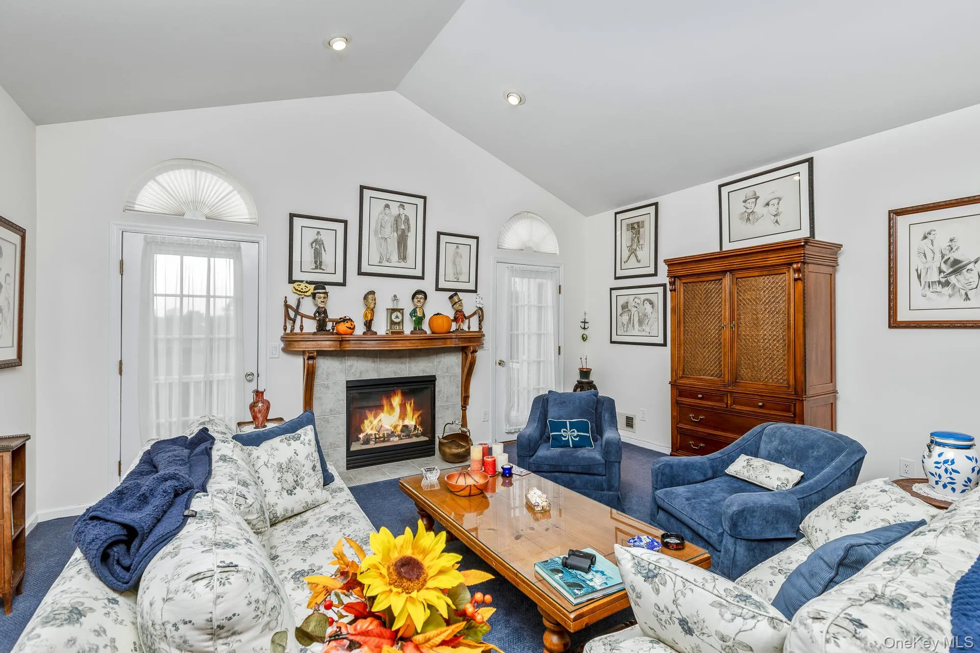 Carpeted living area with a fireplace and vaulted ceiling Carpeted living area with a fireplace and vaulted ceiling