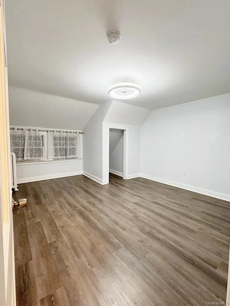 Additional living space featuring wood finished floors and vaulted ceiling Additional living space featuring wood finished floors and vaulted ceiling