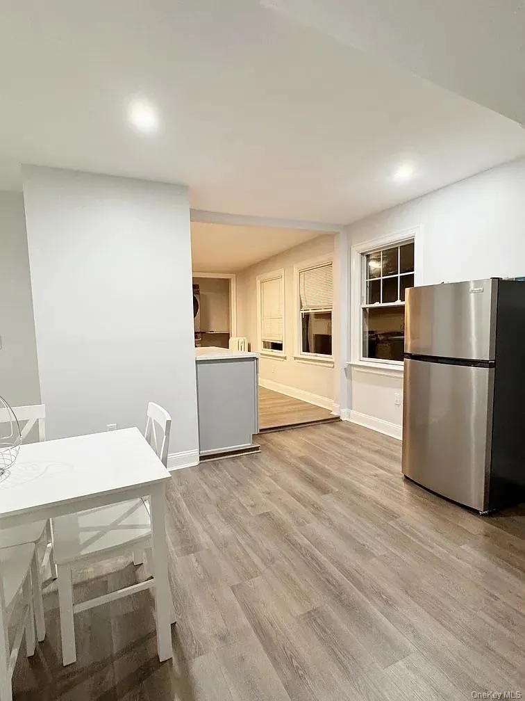 Kitchen with freestanding refrigerator, light wood-style flooring, recessed lighting, and light countertops Kitchen with freestanding refrigerator, light wood-style flooring, recessed lighting, and light countertops