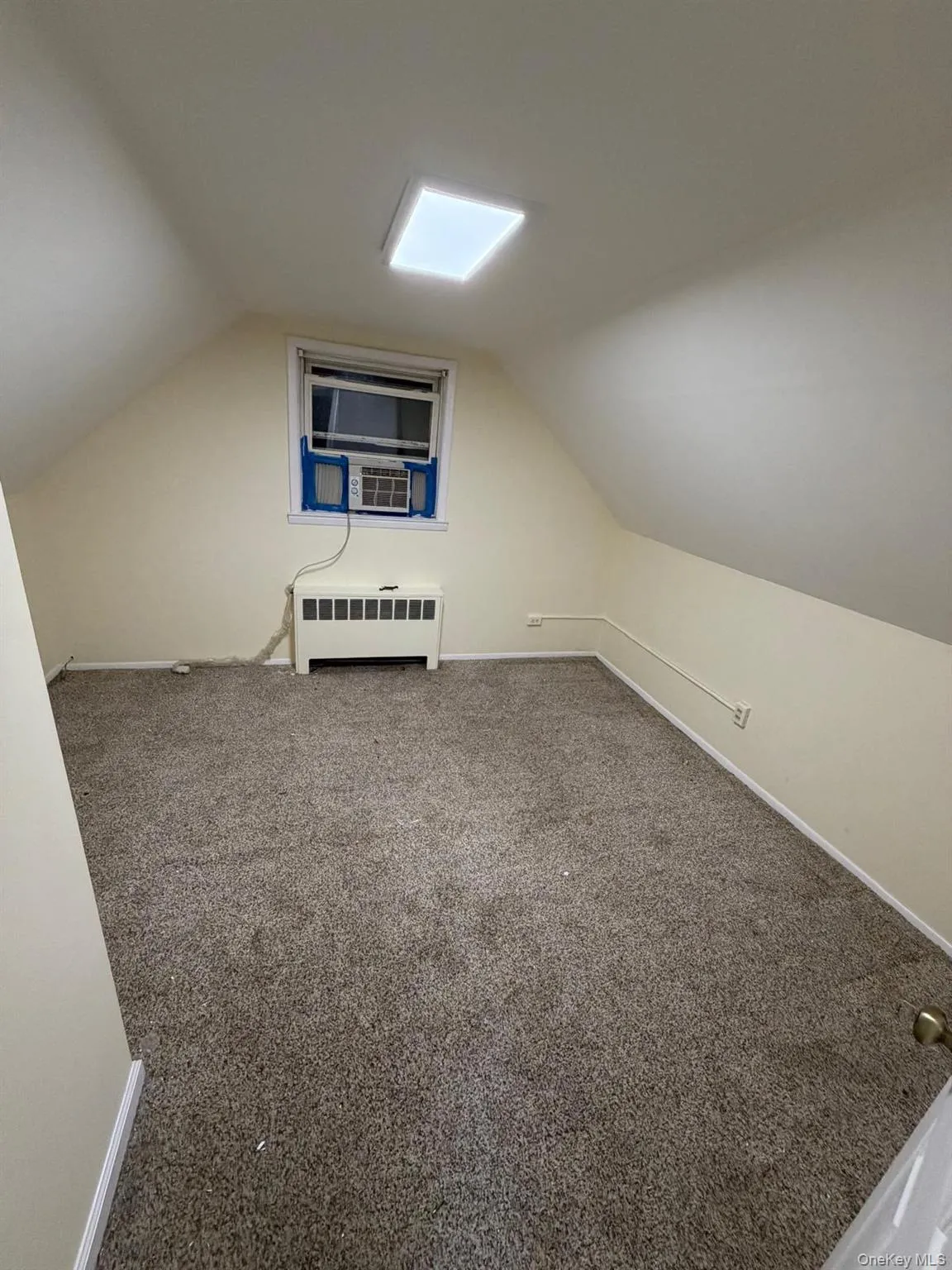Bonus room featuring vaulted ceiling, carpet, and radiator Bonus room featuring vaulted ceiling, carpet, and radiator