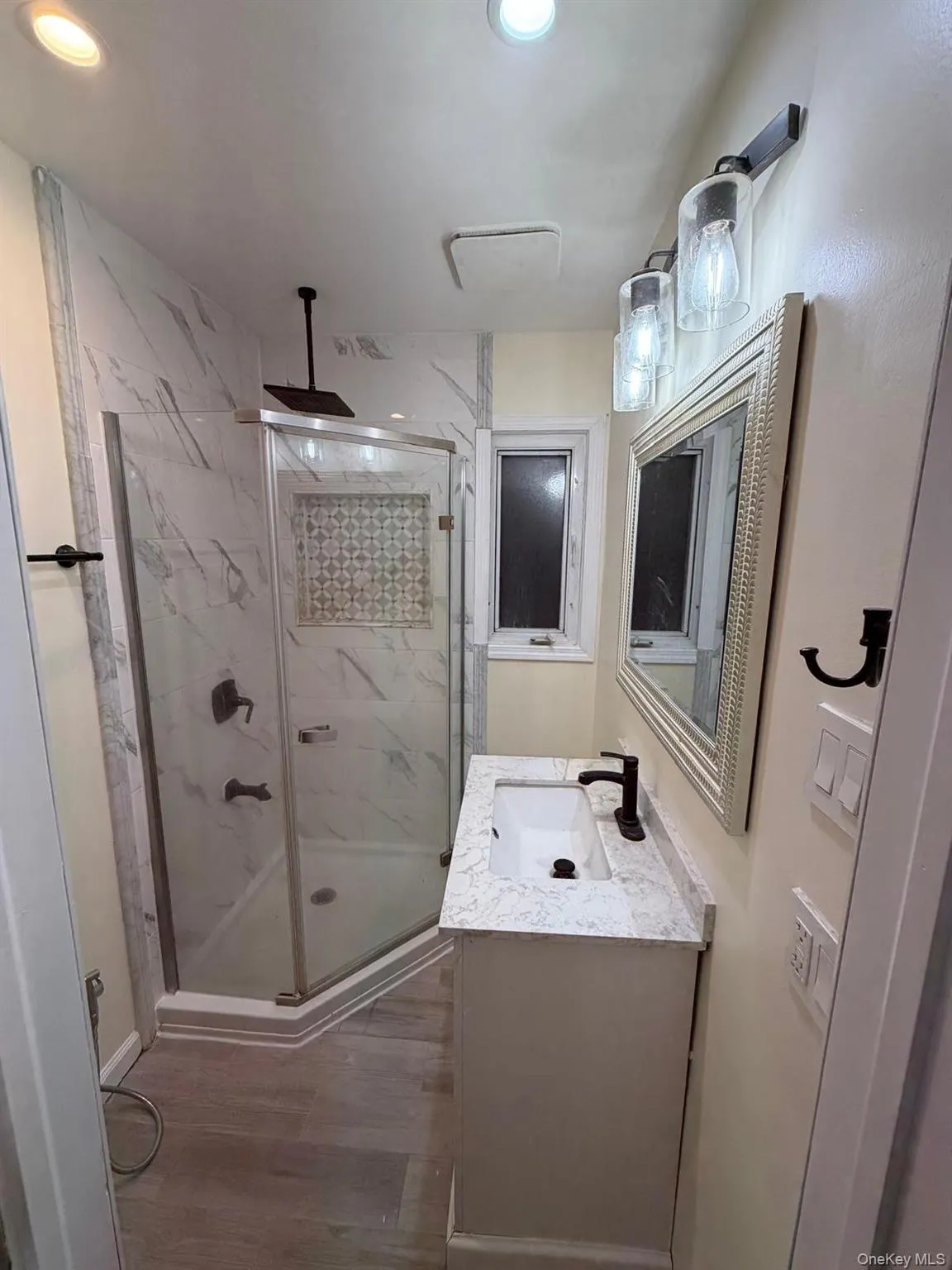 PRIMARY Full bathroom with a marble finish shower, vanity, light wood-style flooring, and recessed lighting PRIMARY Full bathroom with a marble finish shower, vanity, light wood-style flooring, and recessed lighting