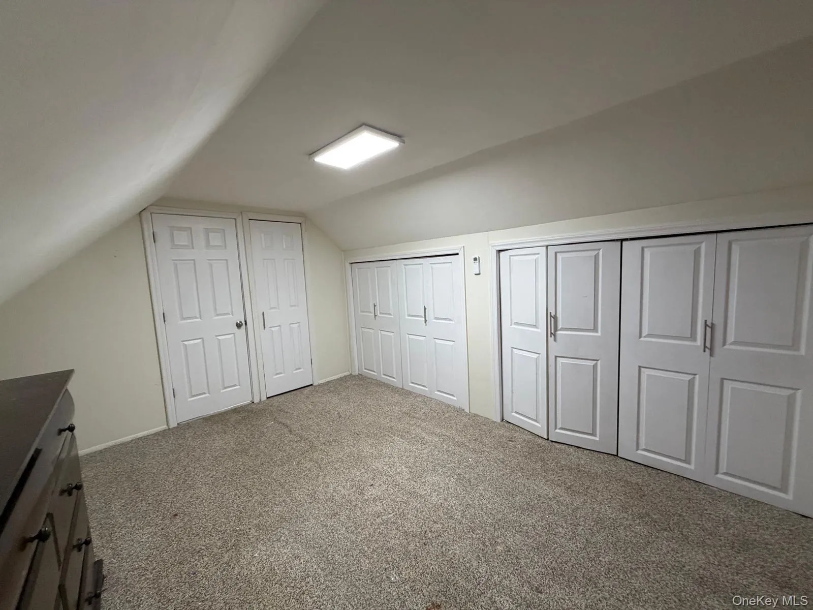 Bonus room featuring vaulted ceiling and carpet Bonus room featuring vaulted ceiling and carpet
