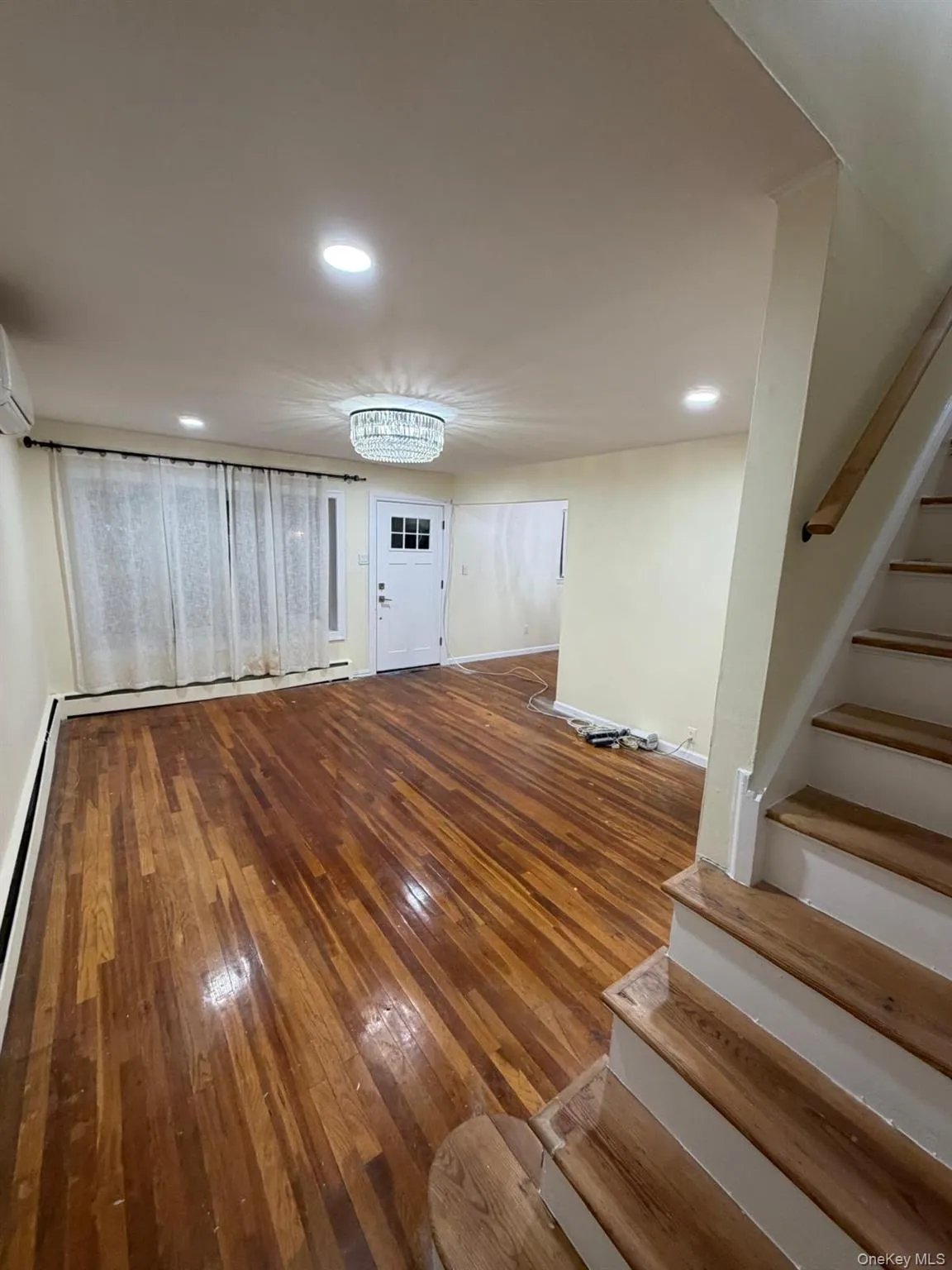 LIVING RM, featuring stairway, hardwood / wood-style flooring, recessed lighting, a baseboard heating unit, and an AC wall unit LIVING RM, featuring stairway, hardwood / wood-style flooring, recessed lighting, a baseboard heating unit, and an AC wall unit