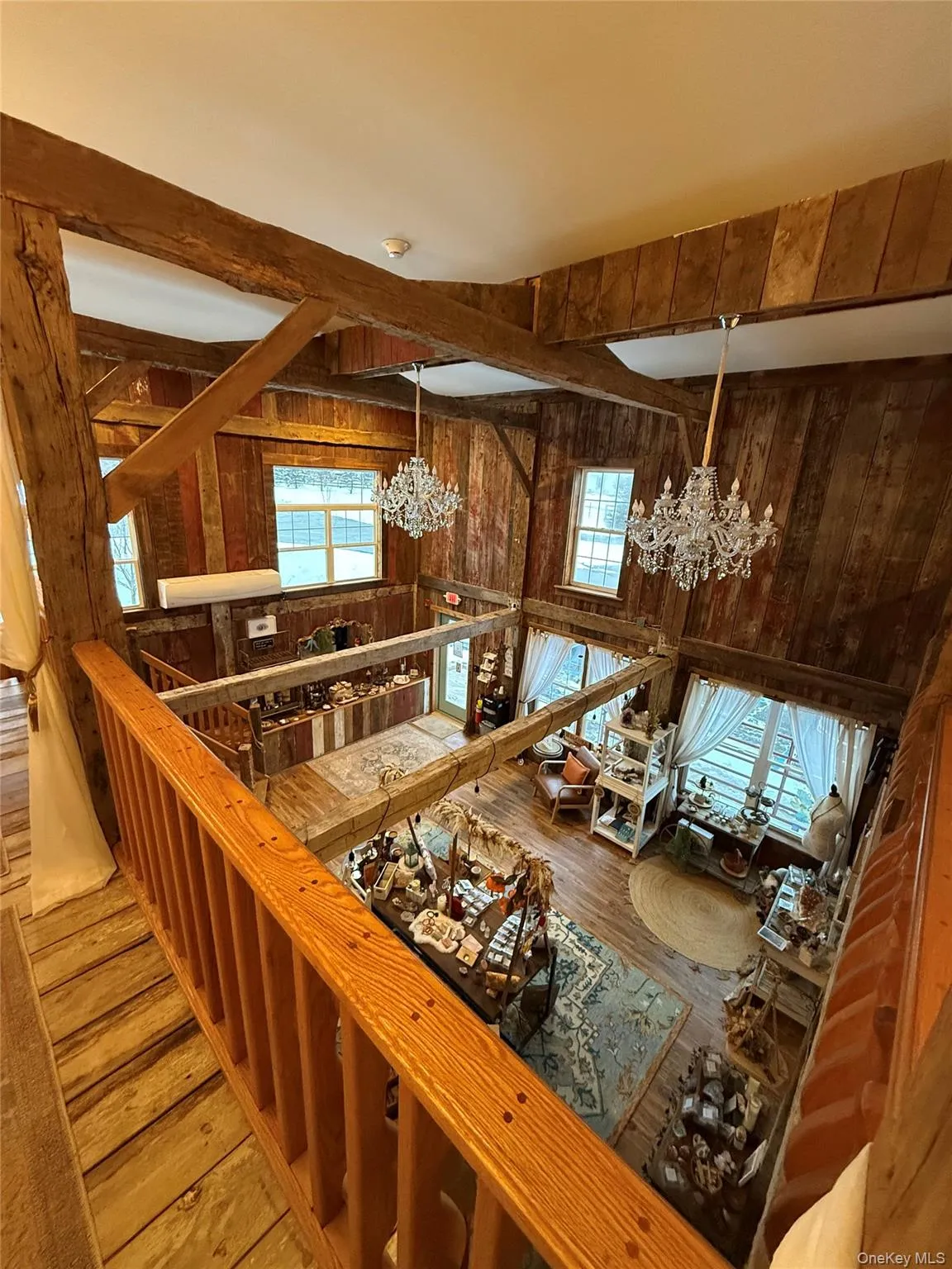 Kitchen with a chandelier, wood-type flooring, wooden walls, healthy amount of natural light, and beam ceiling Kitchen with a chandelier, wood-type flooring, wooden walls, healthy amount of natural light, and beam ceiling