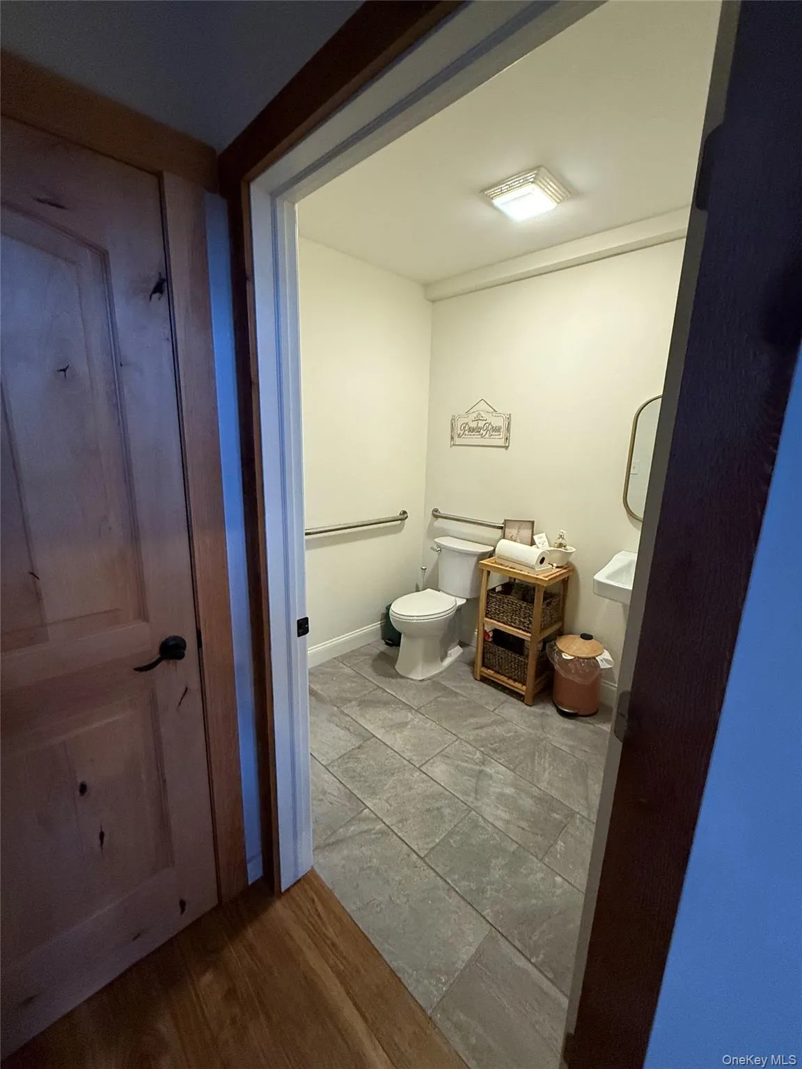 Half bathroom featuring toilet and wood finished floors Half bathroom featuring toilet and wood finished floors