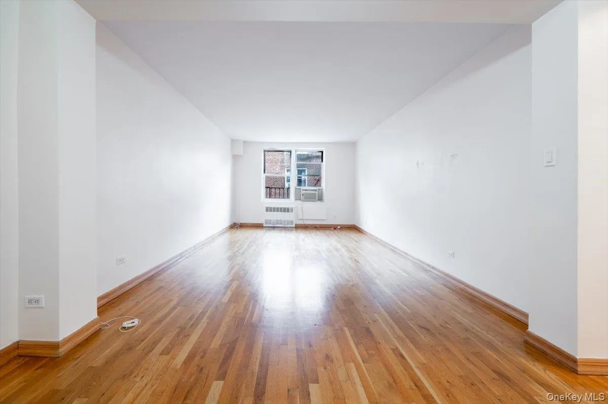 Empty room featuring light wood-type flooring and radiator Empty room featuring light wood-type flooring and radiator