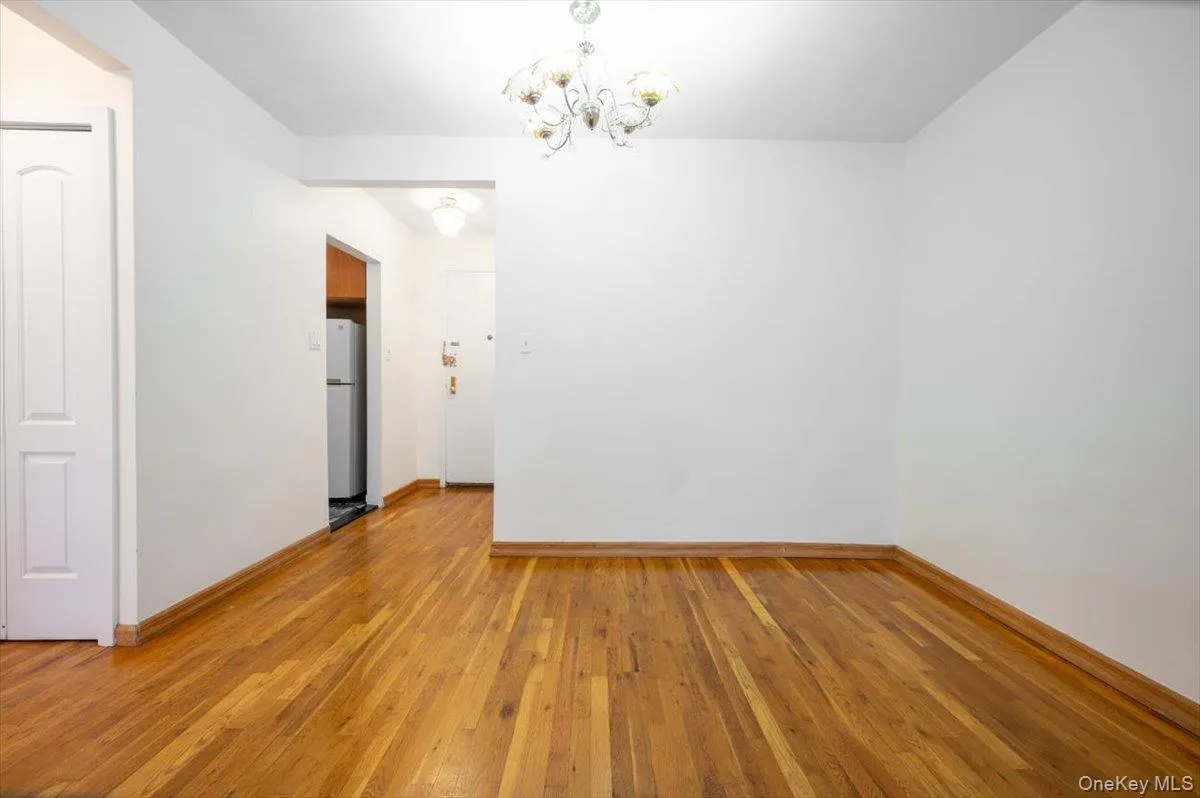 Spare room with a chandelier and light wood finished floors Spare room with a chandelier and light wood finished floors