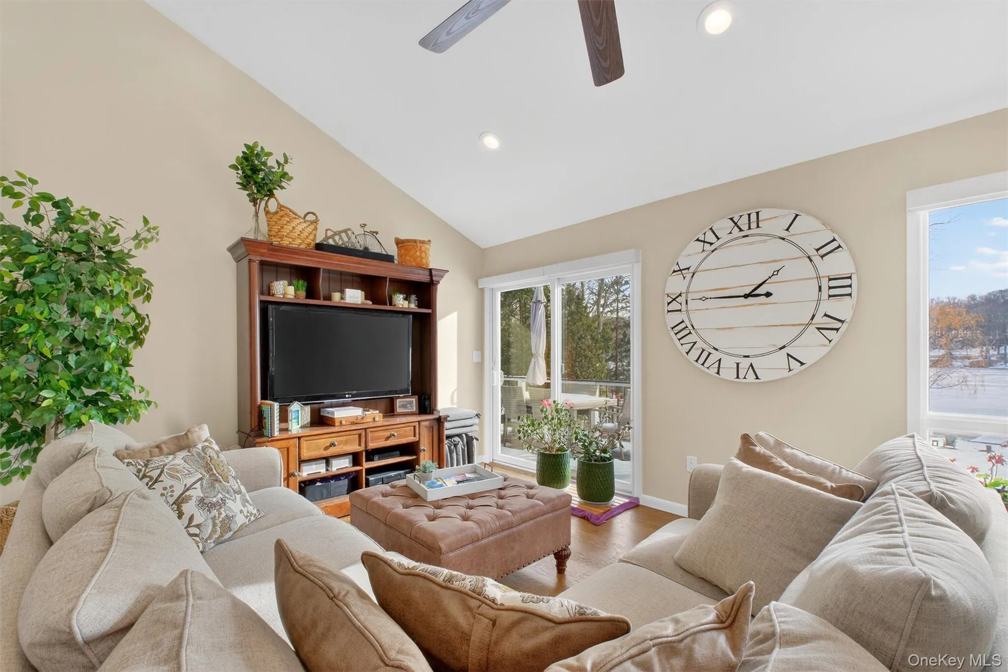 Living area featuring wood finished floors, lofted ceiling, a ceiling fan, and recessed lighting Living area featuring wood finished floors, lofted ceiling, a ceiling fan, and recessed lighting