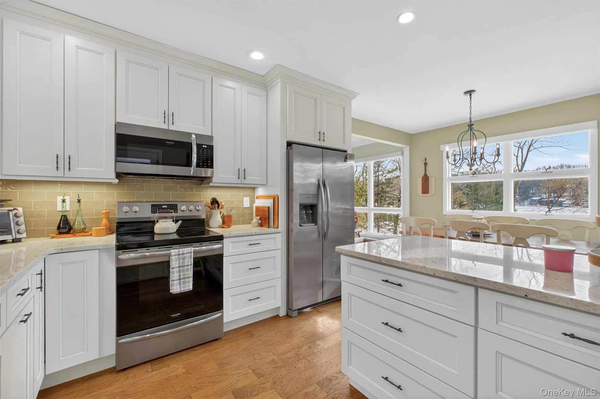 Kitchen featuring appliances with stainless steel finishes, light stone countertops, white cabinetry, and recessed lighting Kitchen featuring appliances with stainless steel finishes, light stone countertops, white cabinetry, and recessed lighting