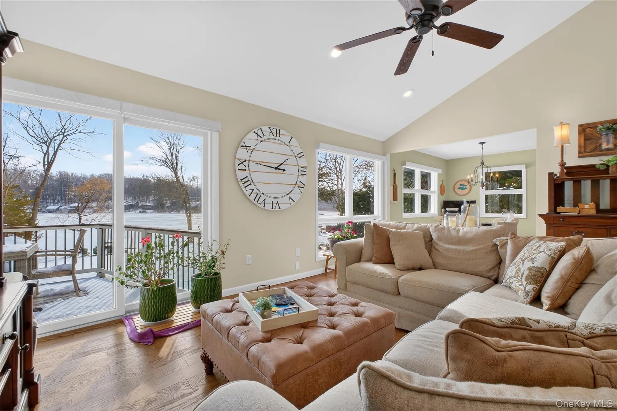 Living area with high vaulted ceiling, wood finished floors, ceiling fan, recessed lighting, and a chandelier Living area with high vaulted ceiling, wood finished floors, ceiling fan, recessed lighting, and a chandelier