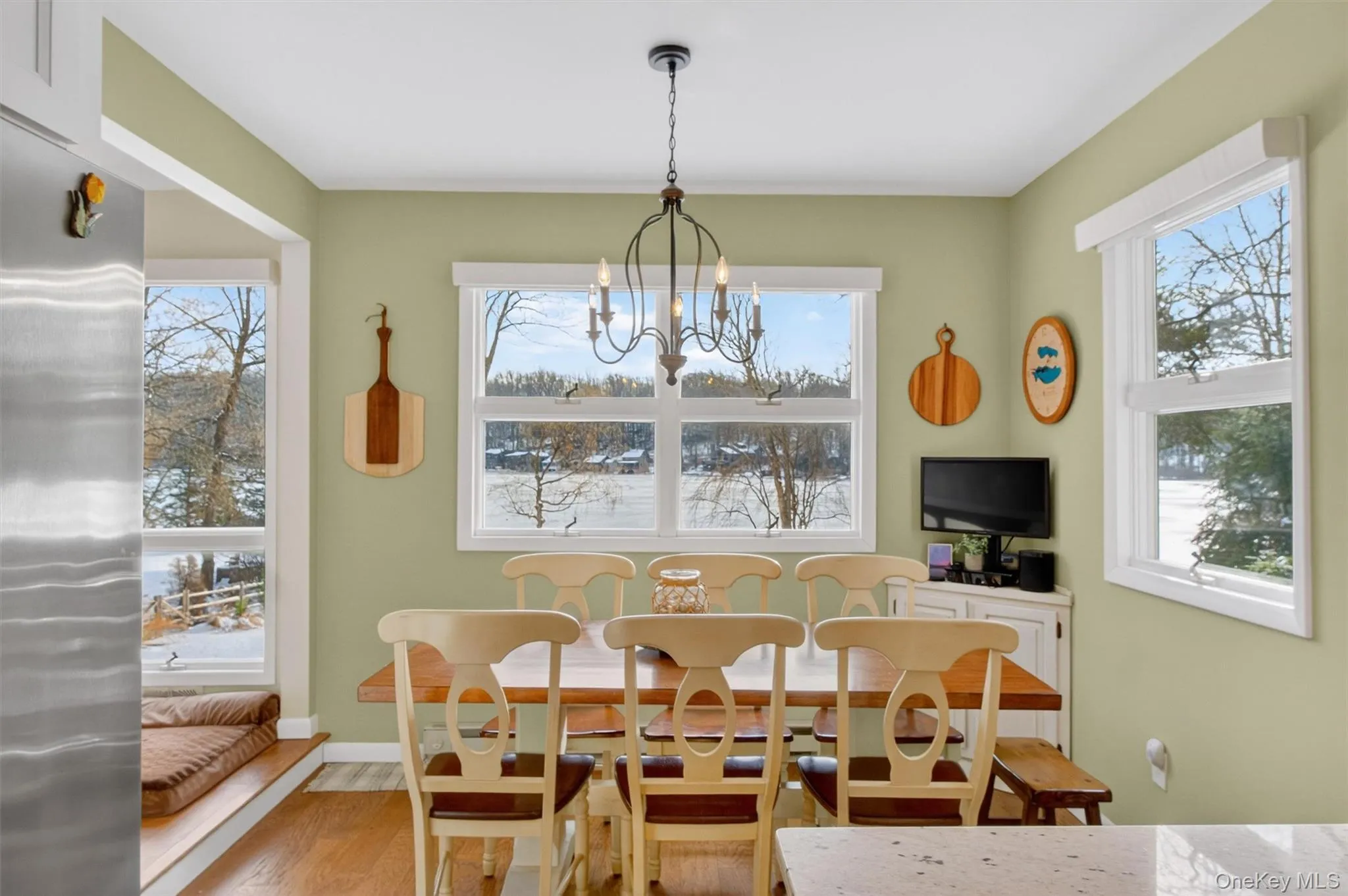 Dining area featuring wood finished floors, a chandelier, and plenty of natural light Dining area featuring wood finished floors, a chandelier, and plenty of natural light