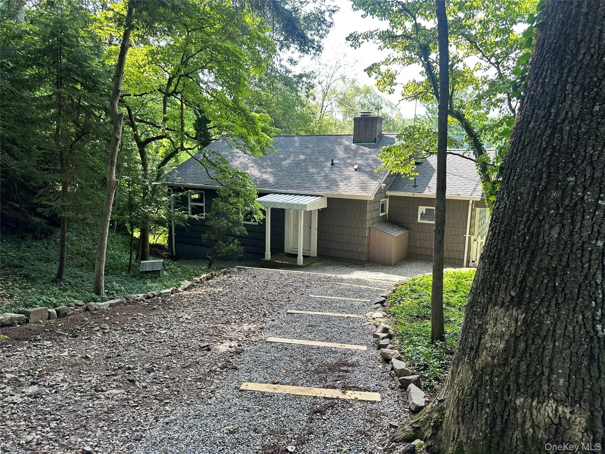 Rear view of house featuring a shingled roof and a chimney Rear view of house featuring a shingled roof and a chimney