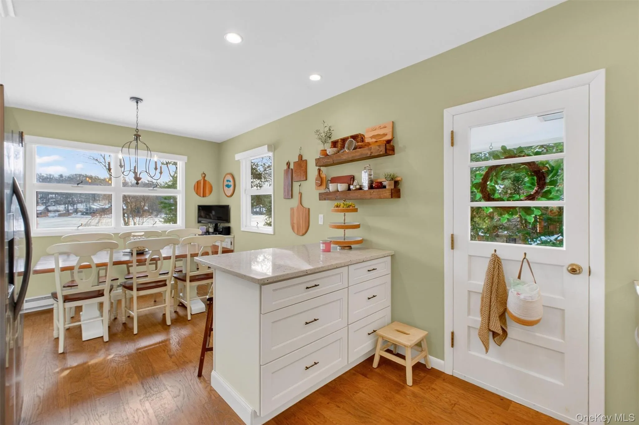 Kitchen with light stone countertops, a peninsula, white cabinetry, pendant lighting, and open shelves Kitchen with light stone countertops, a peninsula, white cabinetry, pendant lighting, and open shelves