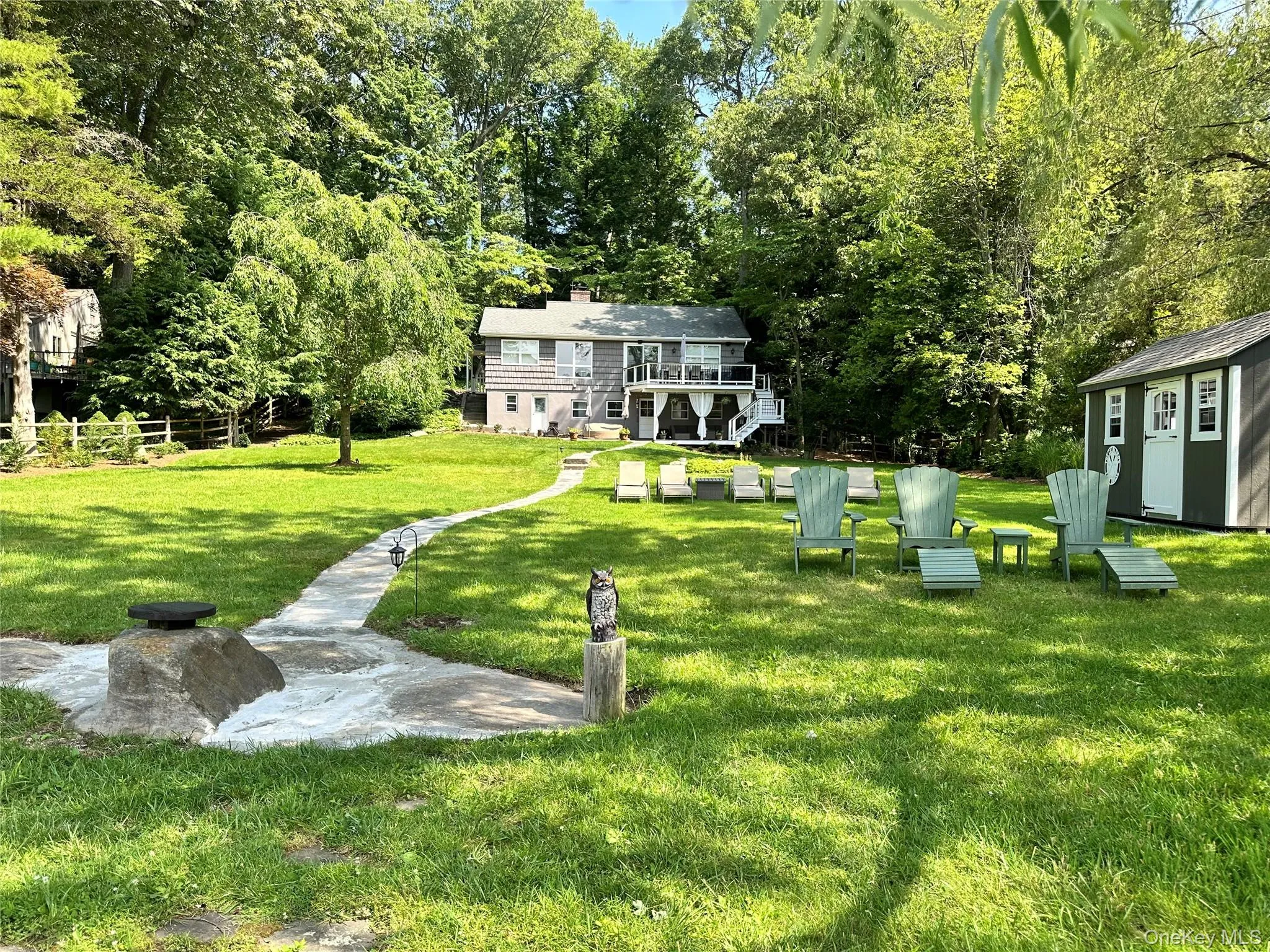 View of grassy yard featuring stairway, a storage shed, and a balcony View of grassy yard featuring stairway, a storage shed, and a balcony