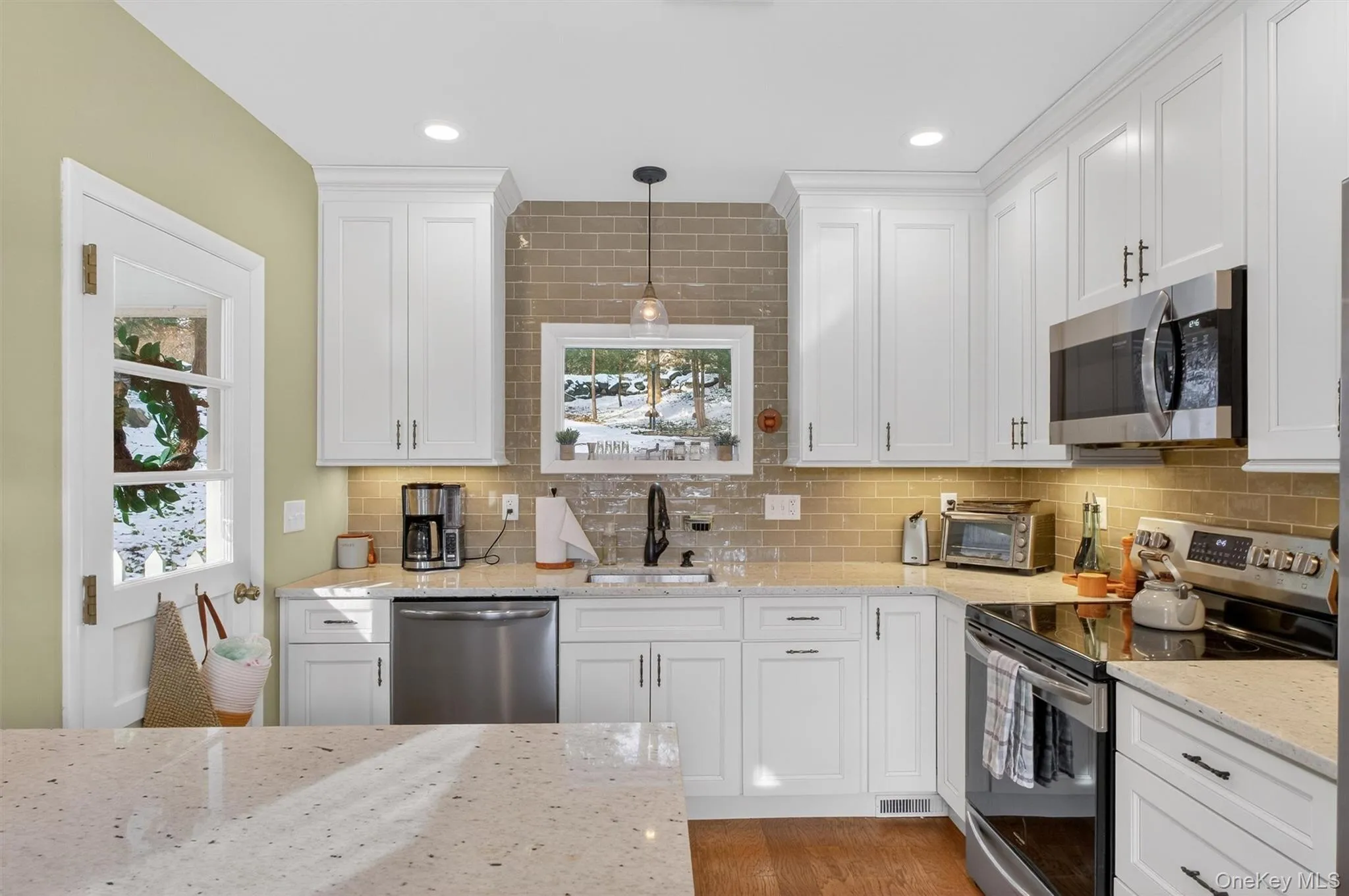 Kitchen with appliances with stainless steel finishes, healthy amount of natural light, white cabinets, and recessed lighting Kitchen with appliances with stainless steel finishes, healthy amount of natural light, white cabinets, and recessed lighting