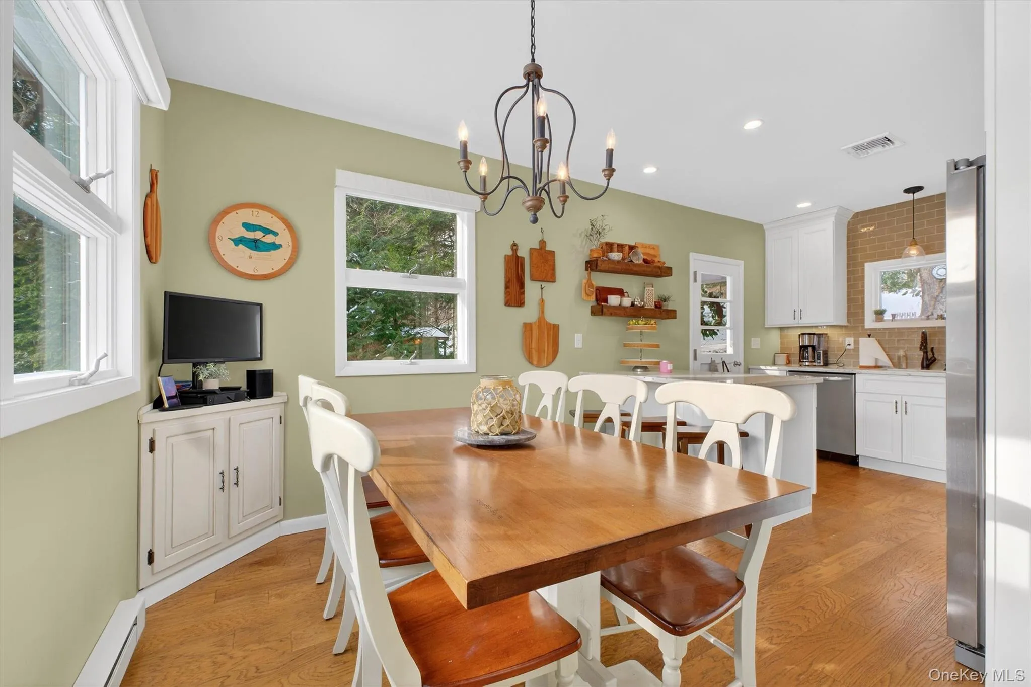 Dining room featuring light wood finished floors, a baseboard radiator, a chandelier, and recessed lighting Dining room featuring light wood finished floors, a baseboard radiator, a chandelier, and recessed lighting