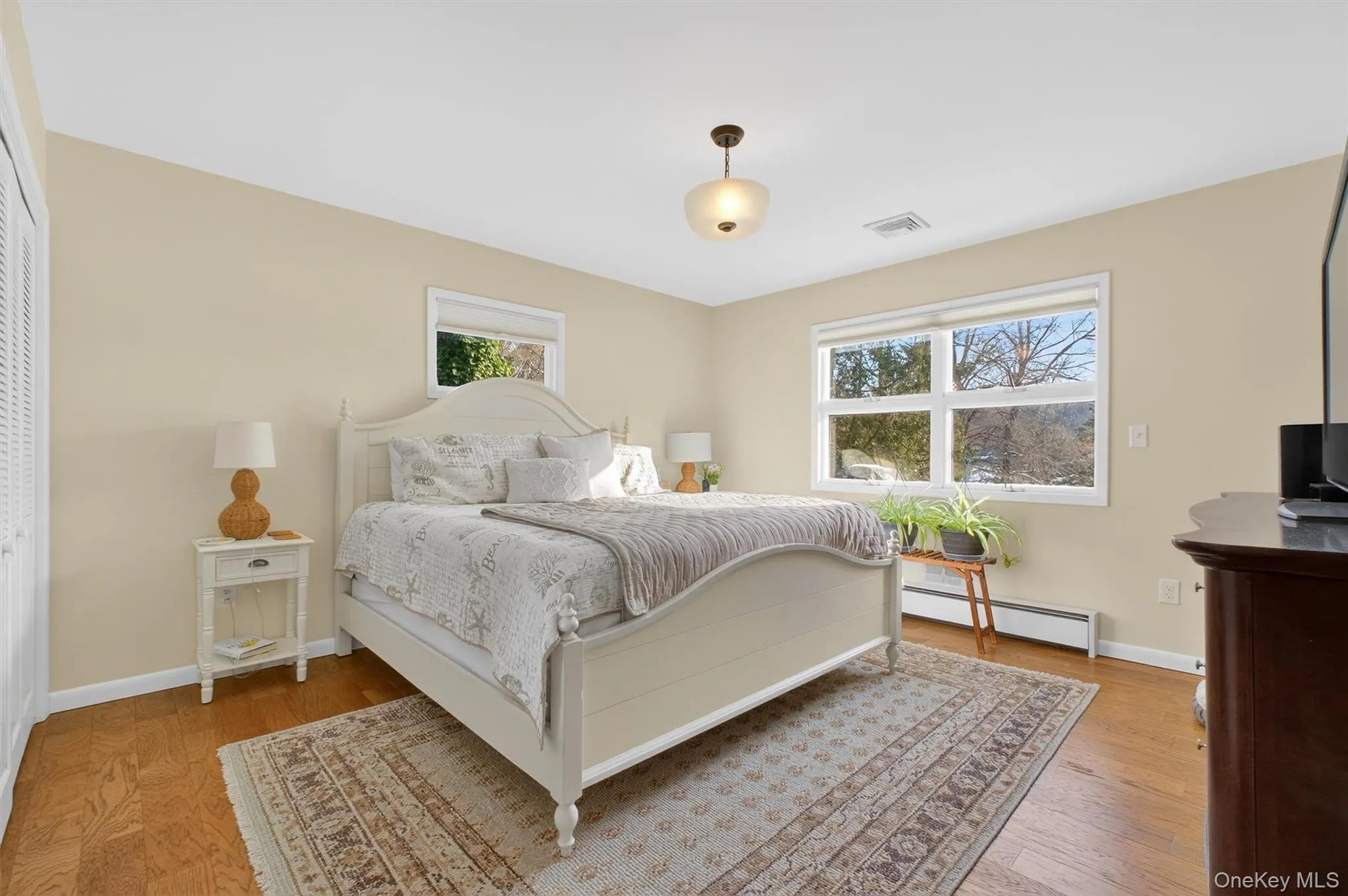 Bedroom with baseboard heating and light wood finished floors Bedroom with baseboard heating and light wood finished floors
