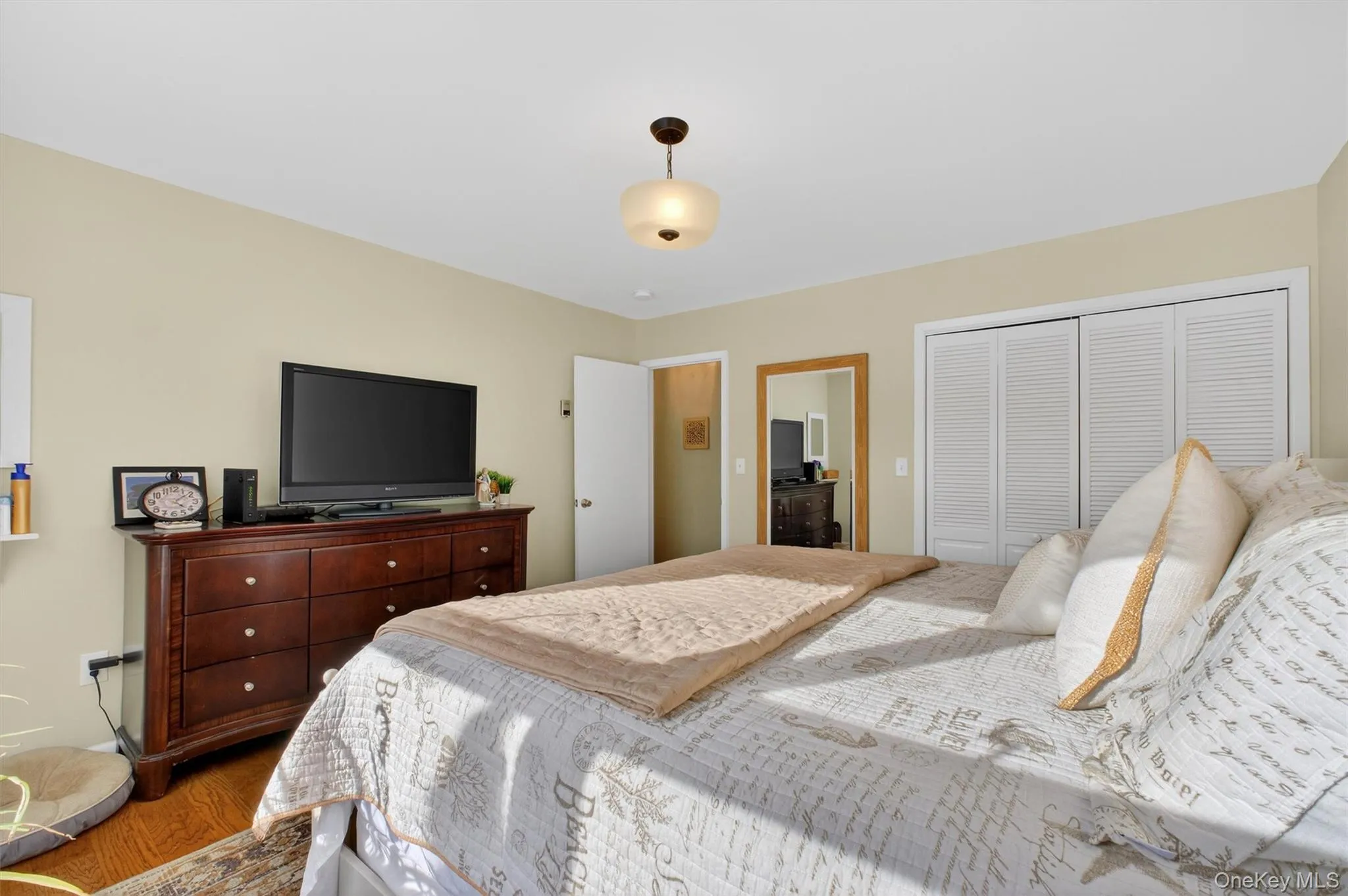 Bedroom featuring a closet and wood finished floors Bedroom featuring a closet and wood finished floors