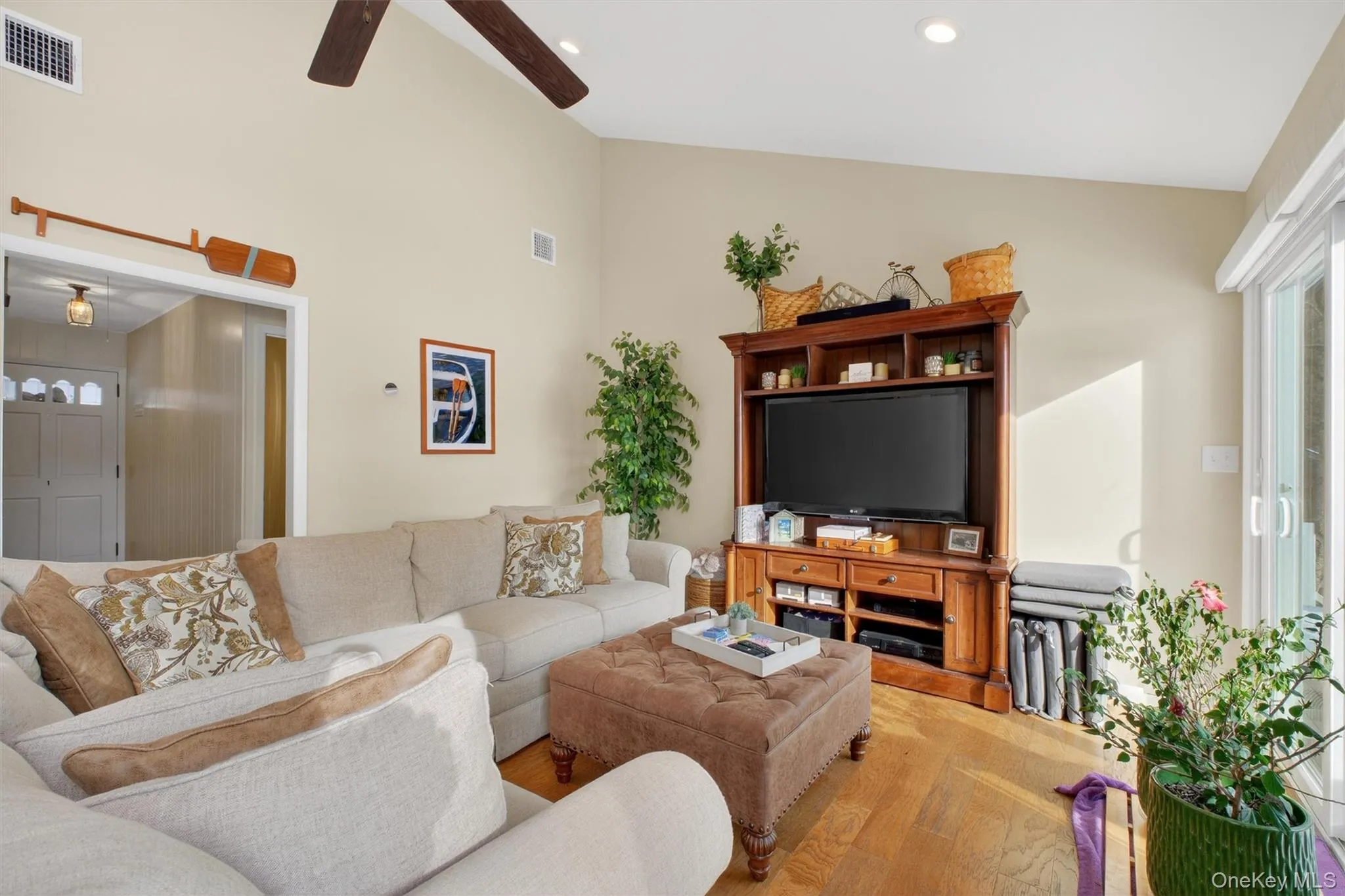 Living area with ceiling fan, wood finished floors, high vaulted ceiling, and recessed lighting Living area with ceiling fan, wood finished floors, high vaulted ceiling, and recessed lighting