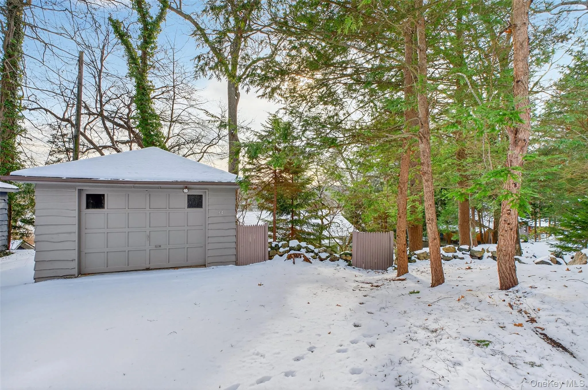 Snow covered garage featuring a detached garage Snow covered garage featuring a detached garage