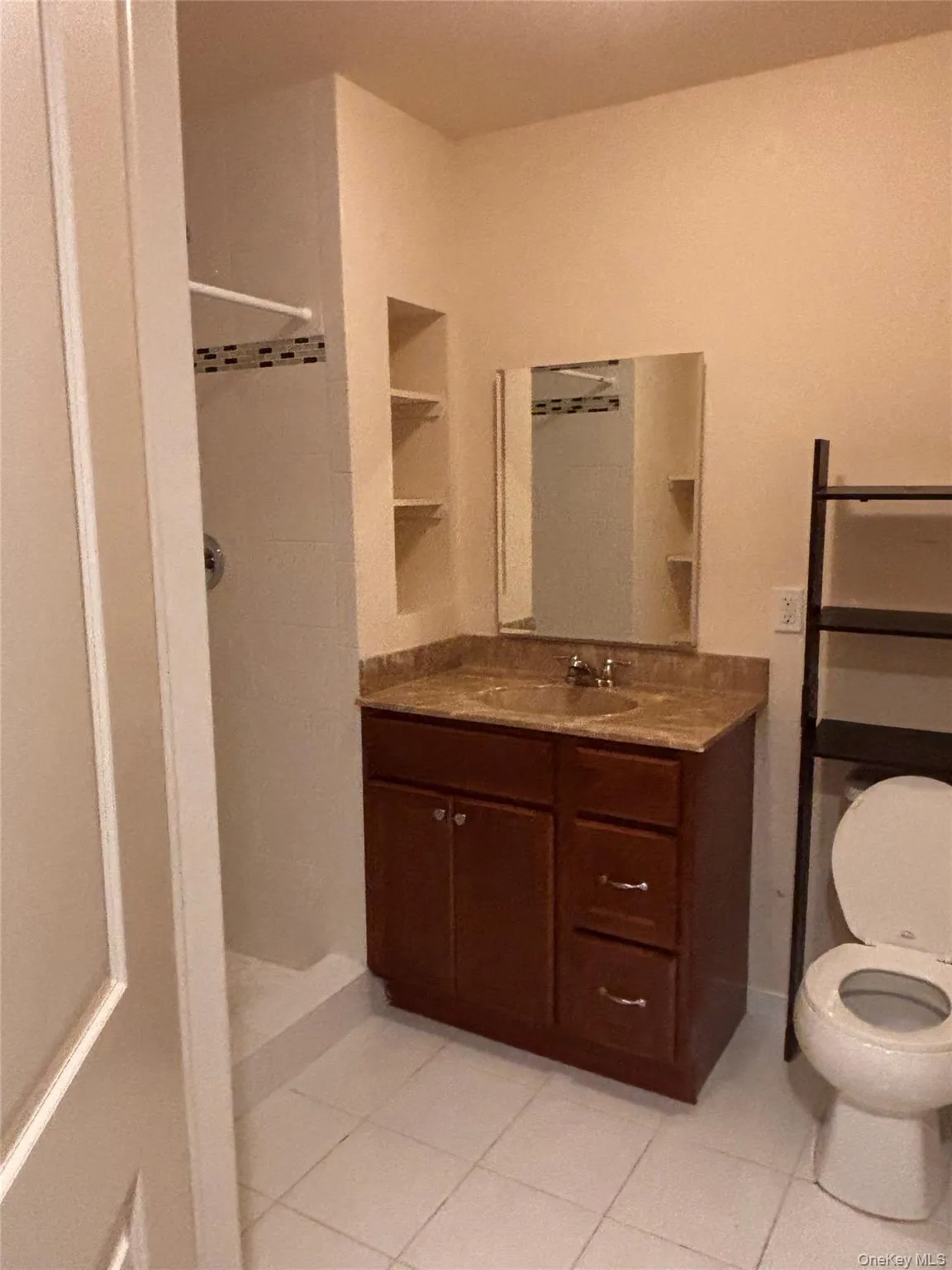 Bathroom featuring a stall shower, light tile patterned flooring, and vanity Bathroom featuring a stall shower, light tile patterned flooring, and vanity