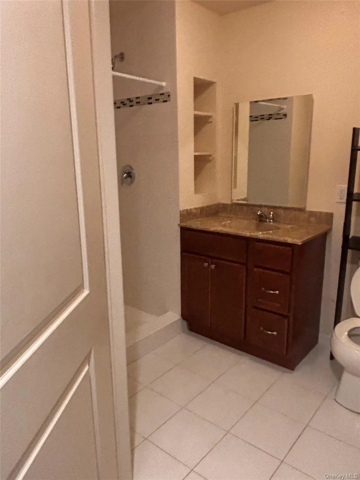 Full bath featuring a shower stall, light tile patterned floors, and vanity Full bath featuring a shower stall, light tile patterned floors, and vanity