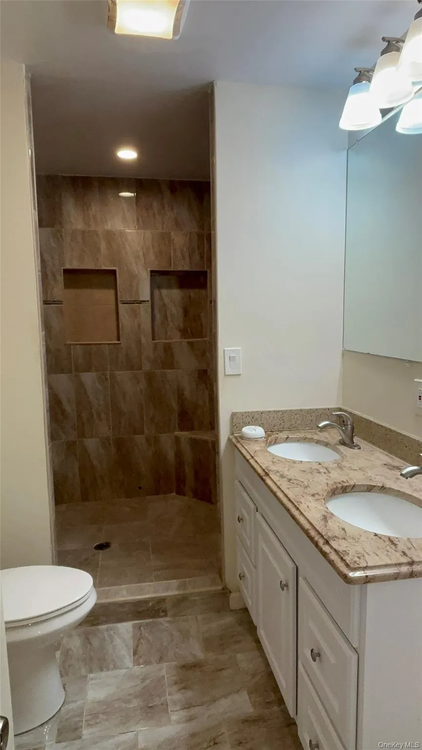 Full bathroom with double vanity double shower head and tiled shower Full bathroom with double vanity double shower head and tiled shower