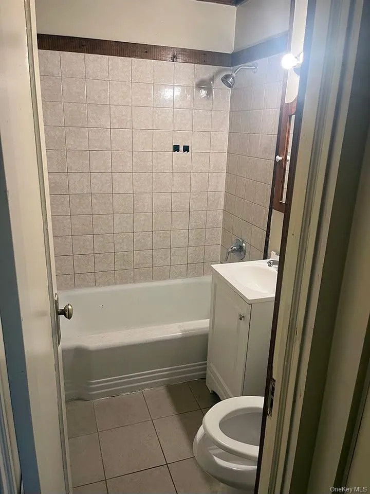 Full bath with light tile patterned flooring, vanity, and shower / tub combination Full bath with light tile patterned flooring, vanity, and shower / tub combination