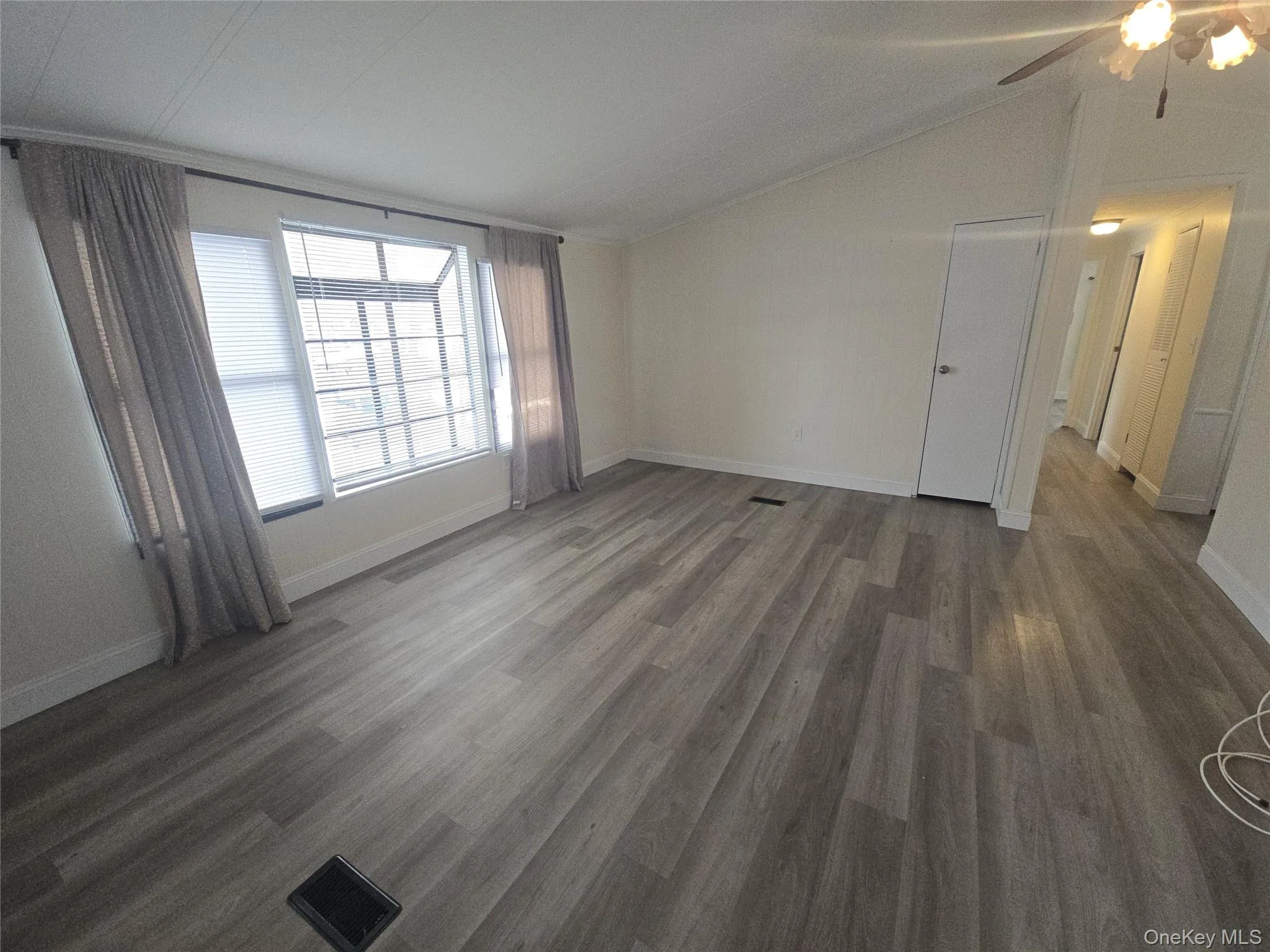 Spare room with vaulted ceiling and dark wood-style flooring Spare room with vaulted ceiling and dark wood-style flooring