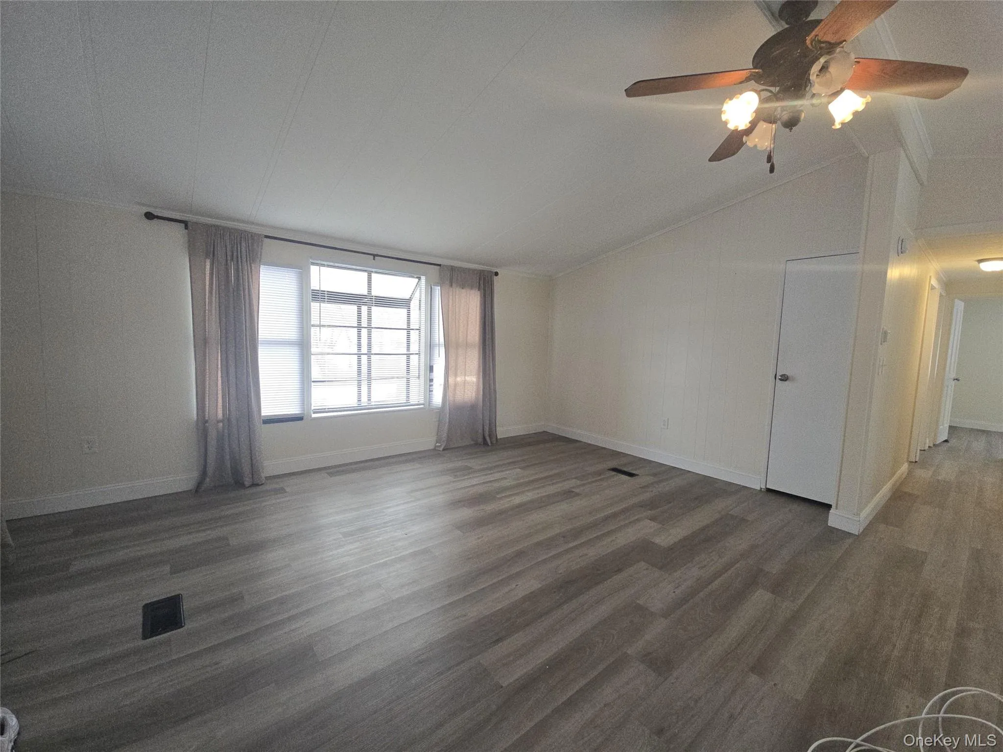 Spare room featuring vaulted ceiling, dark wood-style floors, and ceiling fan Spare room featuring vaulted ceiling, dark wood-style floors, and ceiling fan