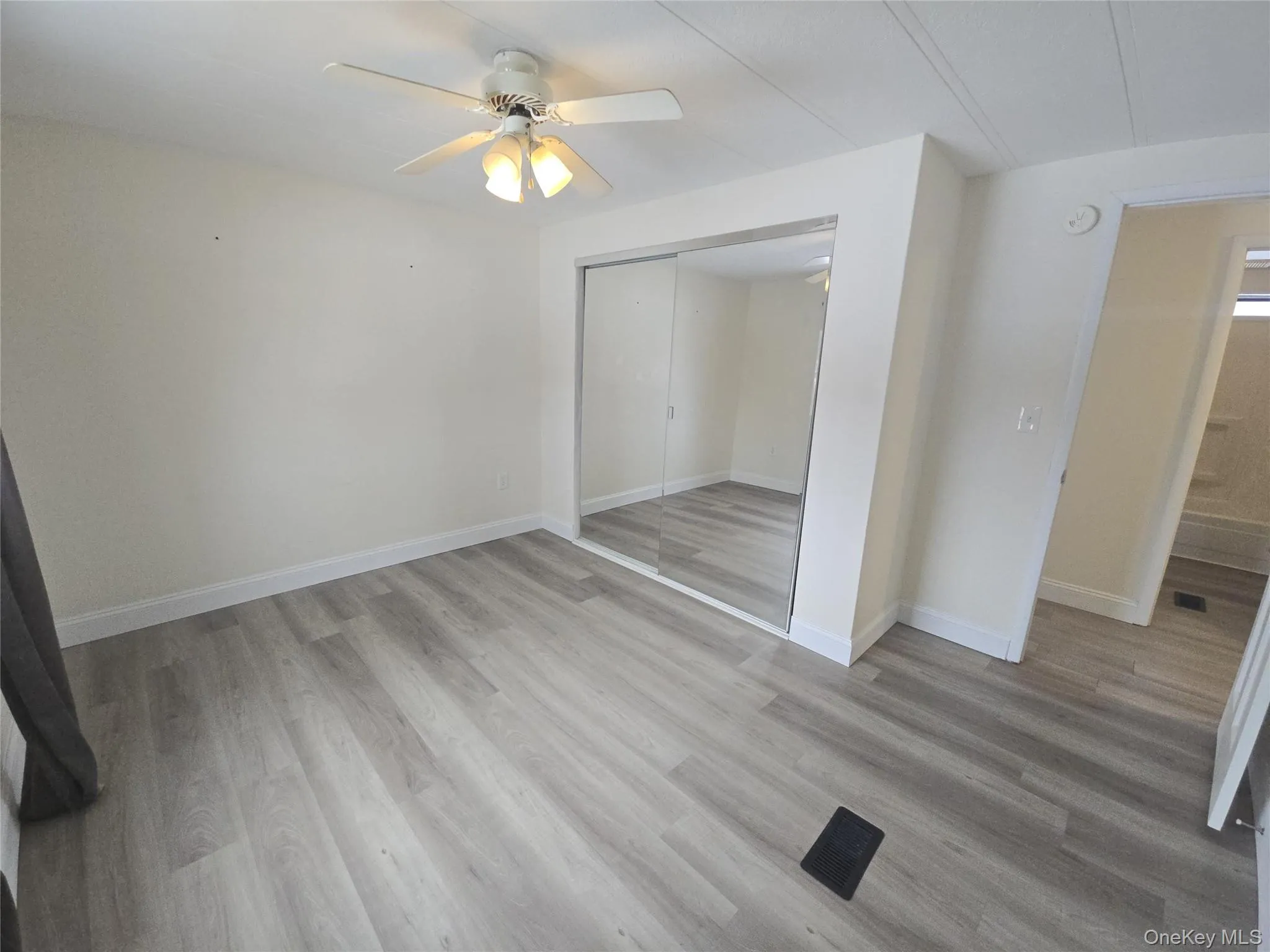 Unfurnished bedroom with light wood finished floors, ceiling fan, and a closet Unfurnished bedroom with light wood finished floors, ceiling fan, and a closet