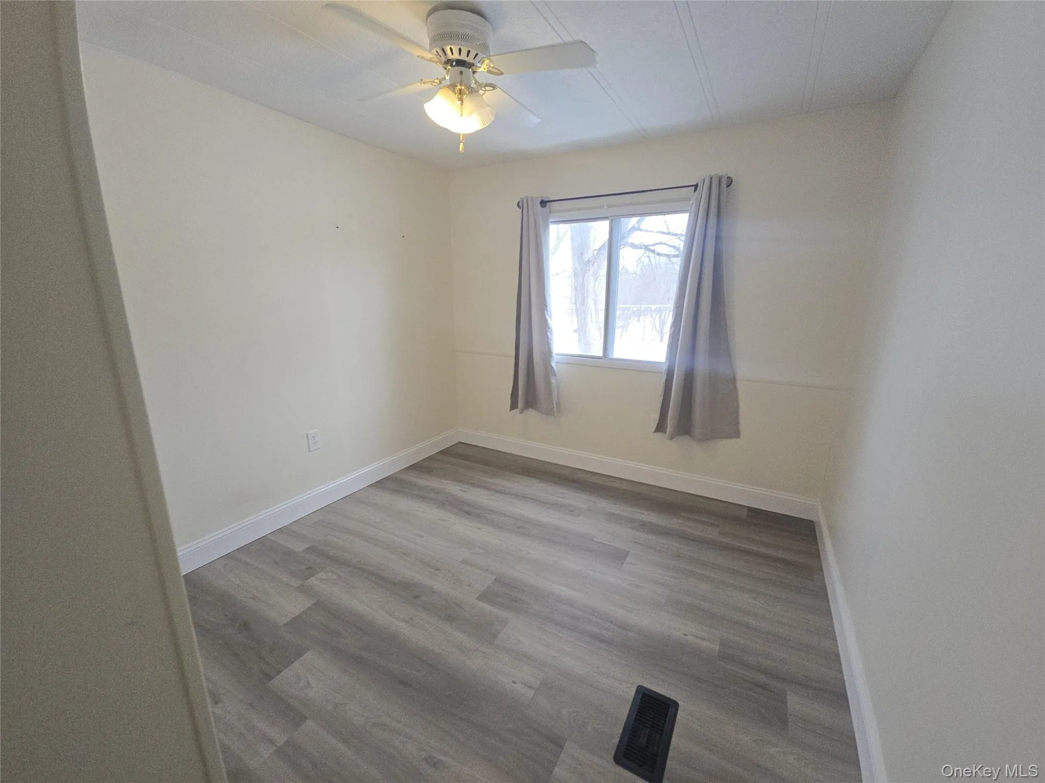Empty room with light wood-style flooring and a ceiling fan Empty room with light wood-style flooring and a ceiling fan