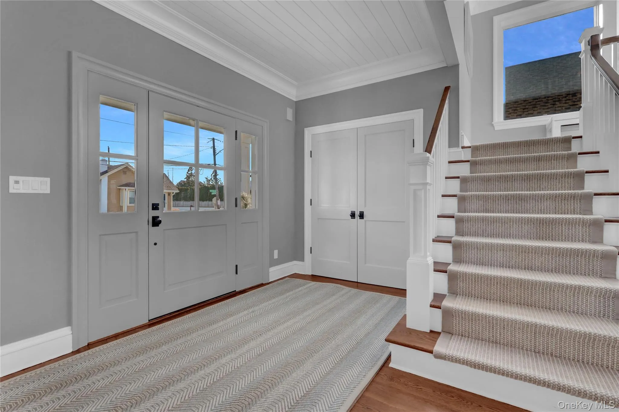 Entryway featuring stairs, light wood-style floors, and ornamental molding Entryway featuring stairs, light wood-style floors, and ornamental molding