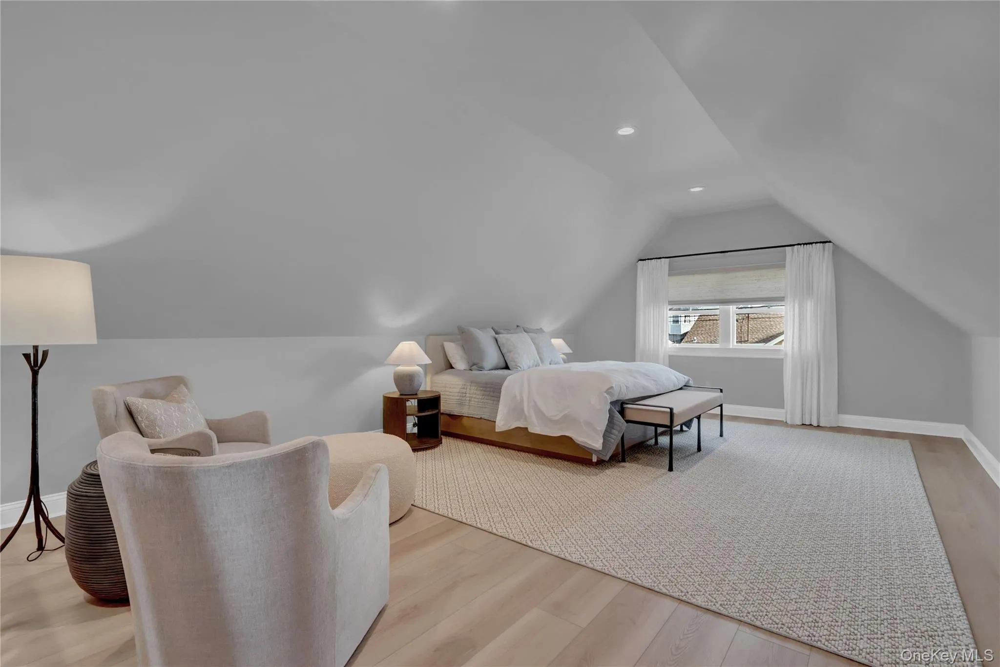 Bedroom featuring light wood-style flooring, vaulted ceiling, and recessed lighting Bedroom featuring light wood-style flooring, vaulted ceiling, and recessed lighting