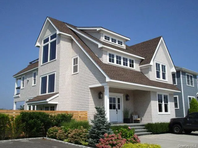 View of front facade featuring covered porch and a shingled roof View of front facade featuring covered porch and a shingled roof