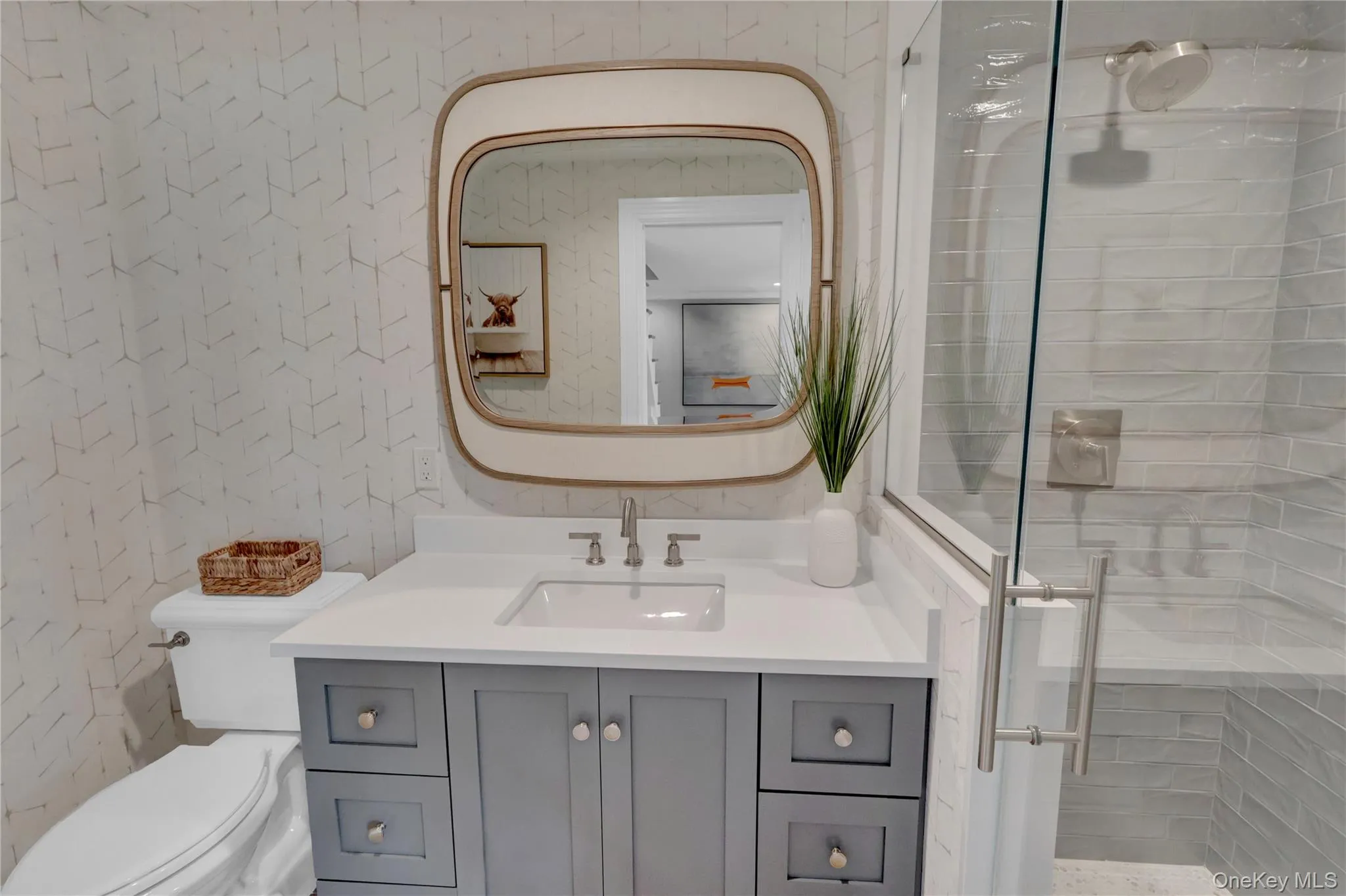 Full bathroom with a shower stall, vanity, and wallpapered walls Full bathroom with a shower stall, vanity, and wallpapered walls
