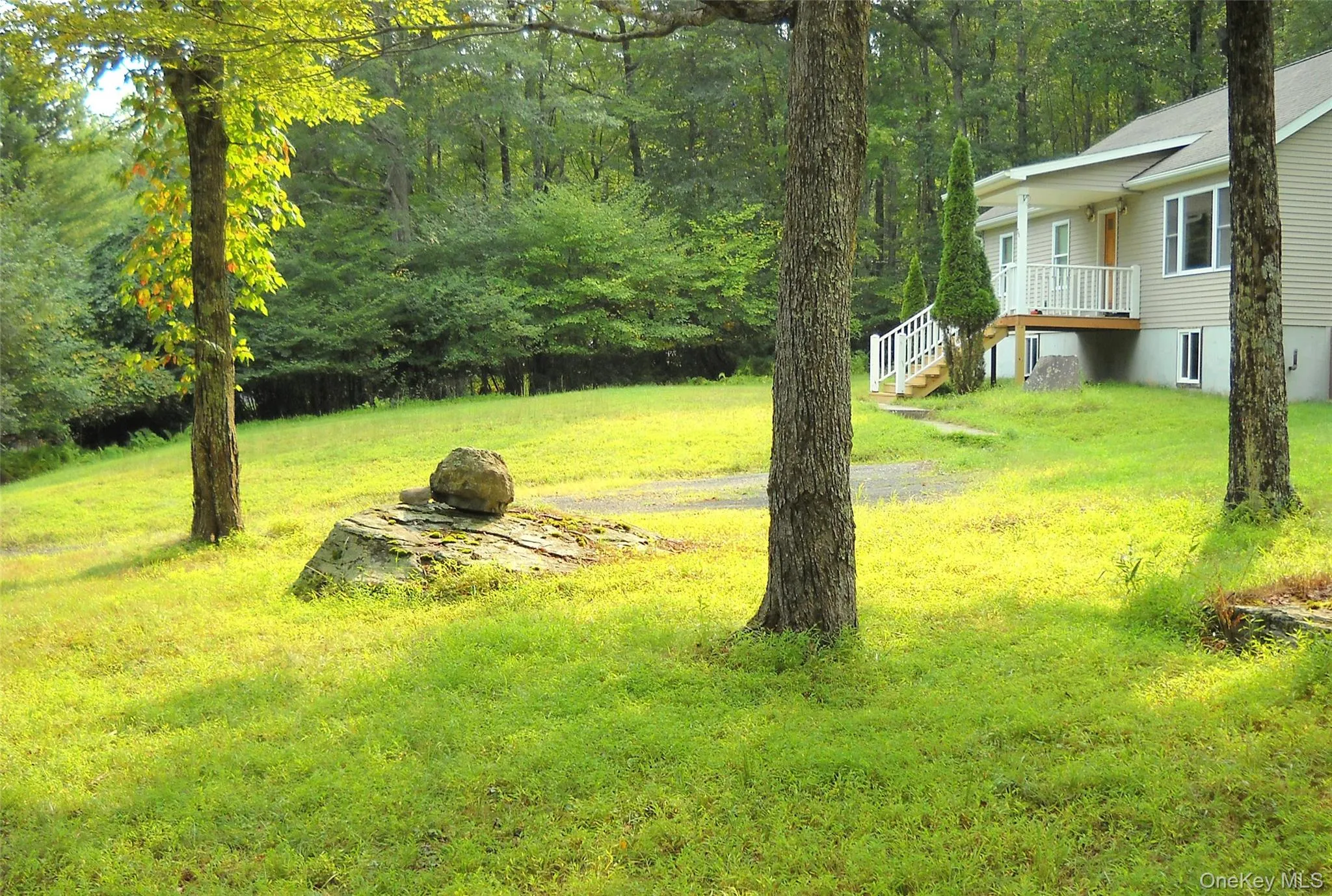 View of grassy yard with stairway and a view of trees View of grassy yard with stairway and a view of trees