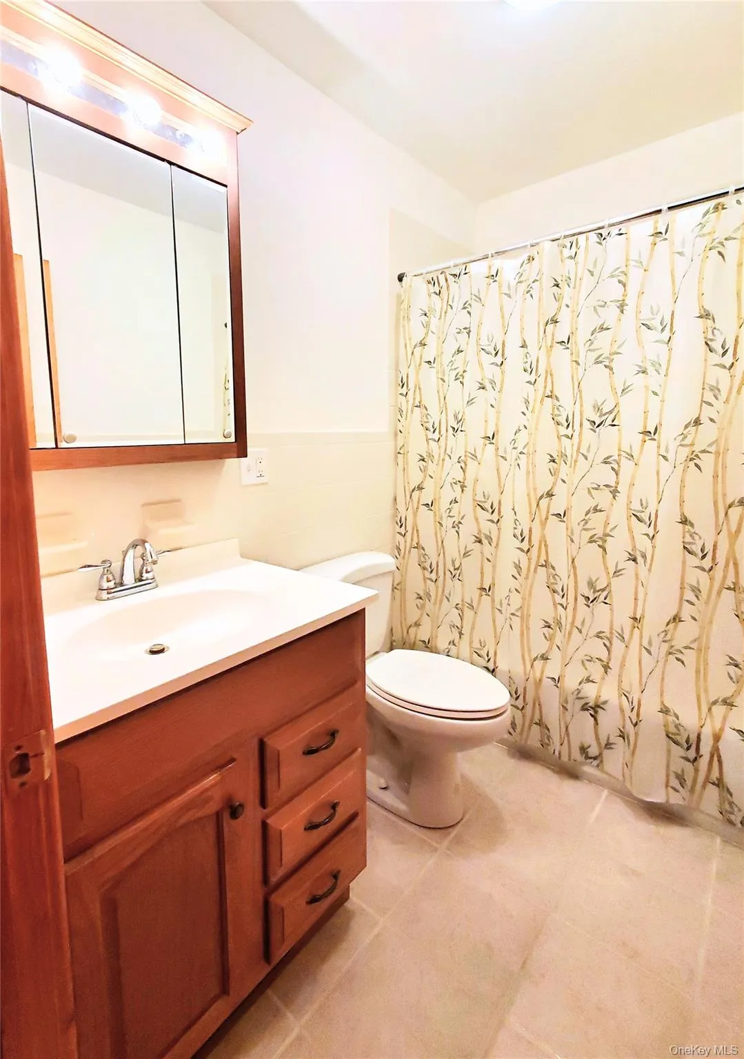 Full bath with vanity, bath and shower combo and light tile patterned floors Full bath with vanity, bath and shower combo and light tile patterned floors