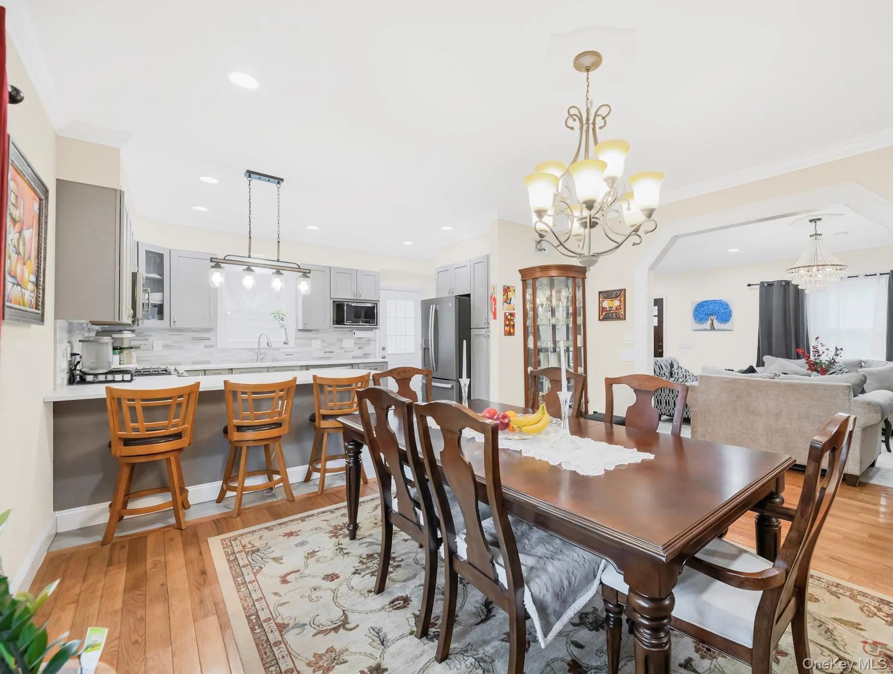 Dining area featuring ornamental molding, light wood-style flooring, recessed lighting, and a chandelier Dining area featuring ornamental molding, light wood-style flooring, recessed lighting, and a chandelier
