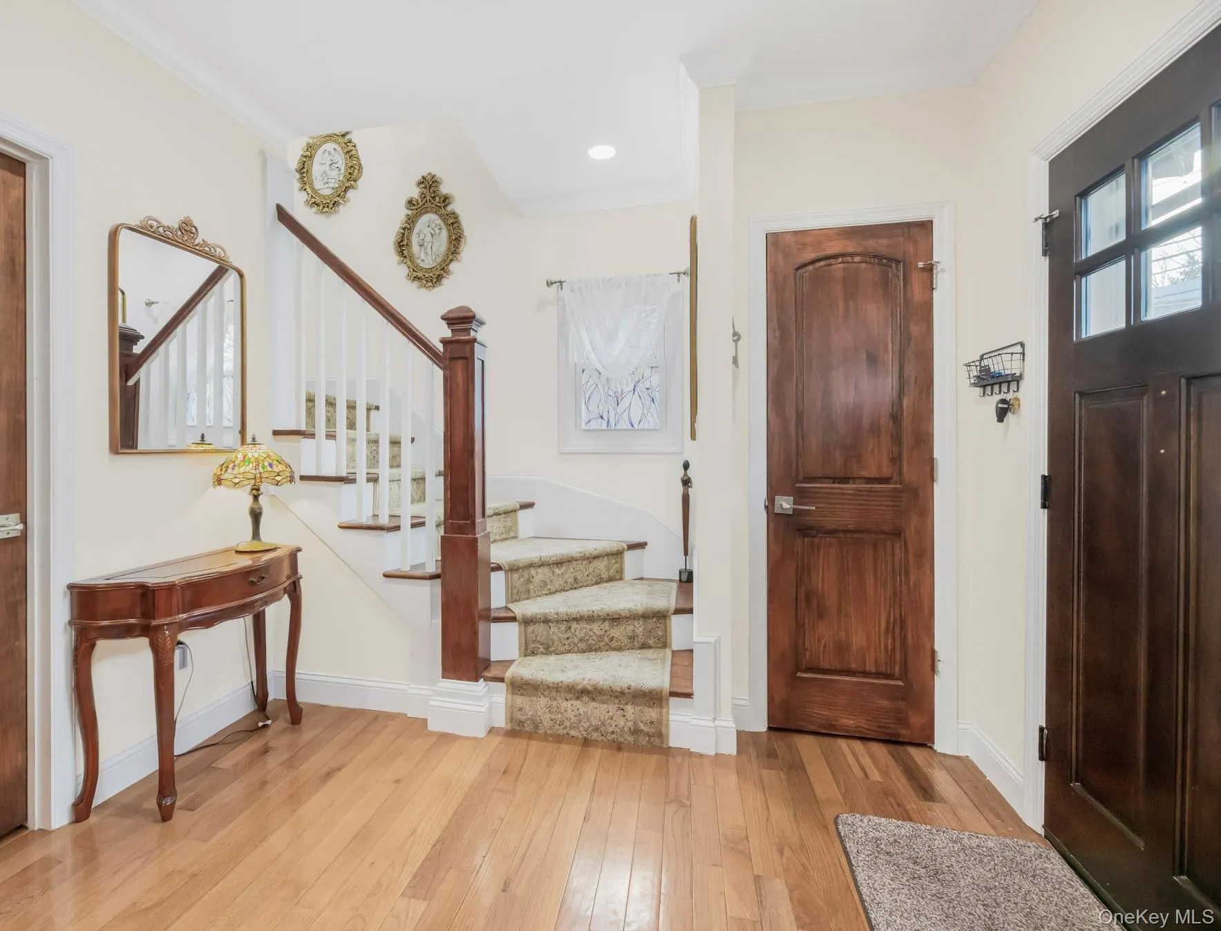 Foyer entrance featuring stairs, light wood-type flooring, and crown molding Foyer entrance featuring stairs, light wood-type flooring, and crown molding