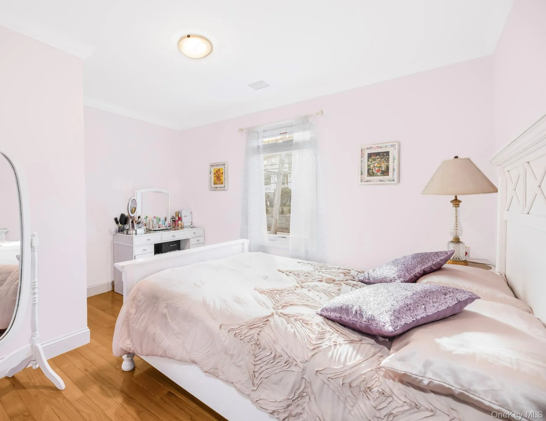 Bedroom featuring wood finished floors and crown molding Bedroom featuring wood finished floors and crown molding