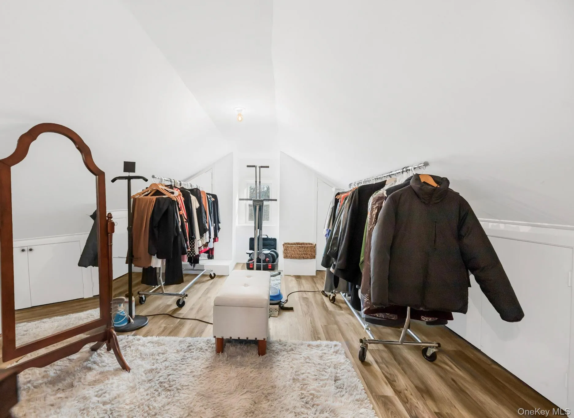 Walk in closet with vaulted ceiling and wood finished floors Walk in closet with vaulted ceiling and wood finished floors